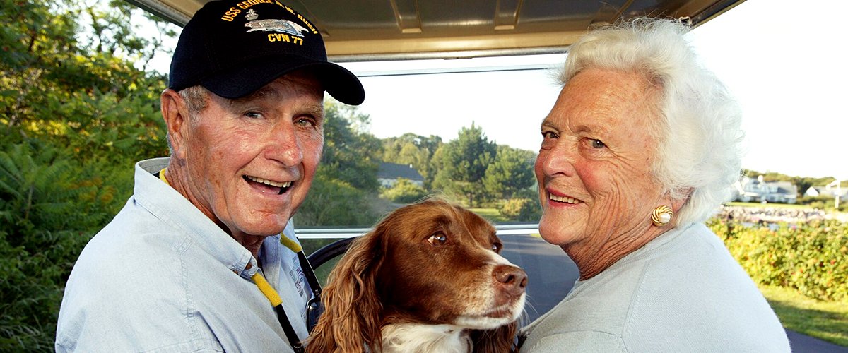 Former U.S. president George H. W. Bush and wife, Barbara Bush, in the back of a golf cart with their dog Millie at Walker's Point on August 25, 2004 | Photo: Getty Images