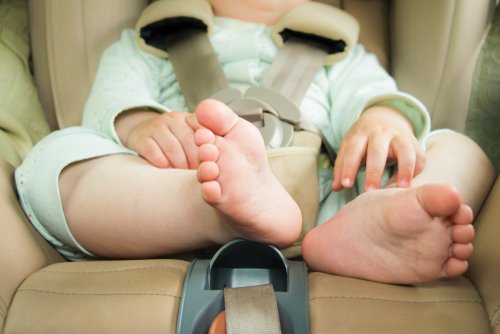 Piernas de bebé sentado en silla especial para autos. | Foto: Shutterstock  
