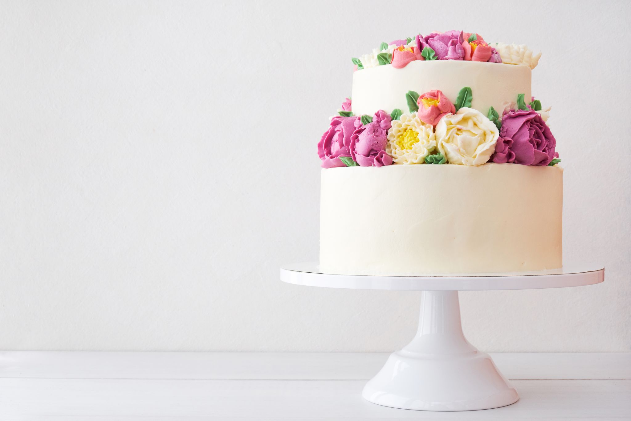 A two-tiered white cake with flower decorations. | Source: Getty Images