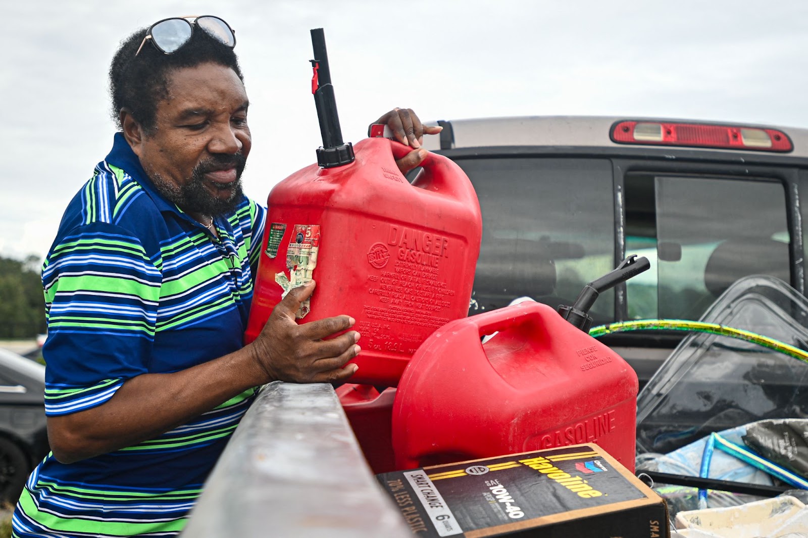 A man loading gas containers into his car  ahead of Hurricane Milton's expected landfall in Lakeland, Florida. | Source: Getty Images