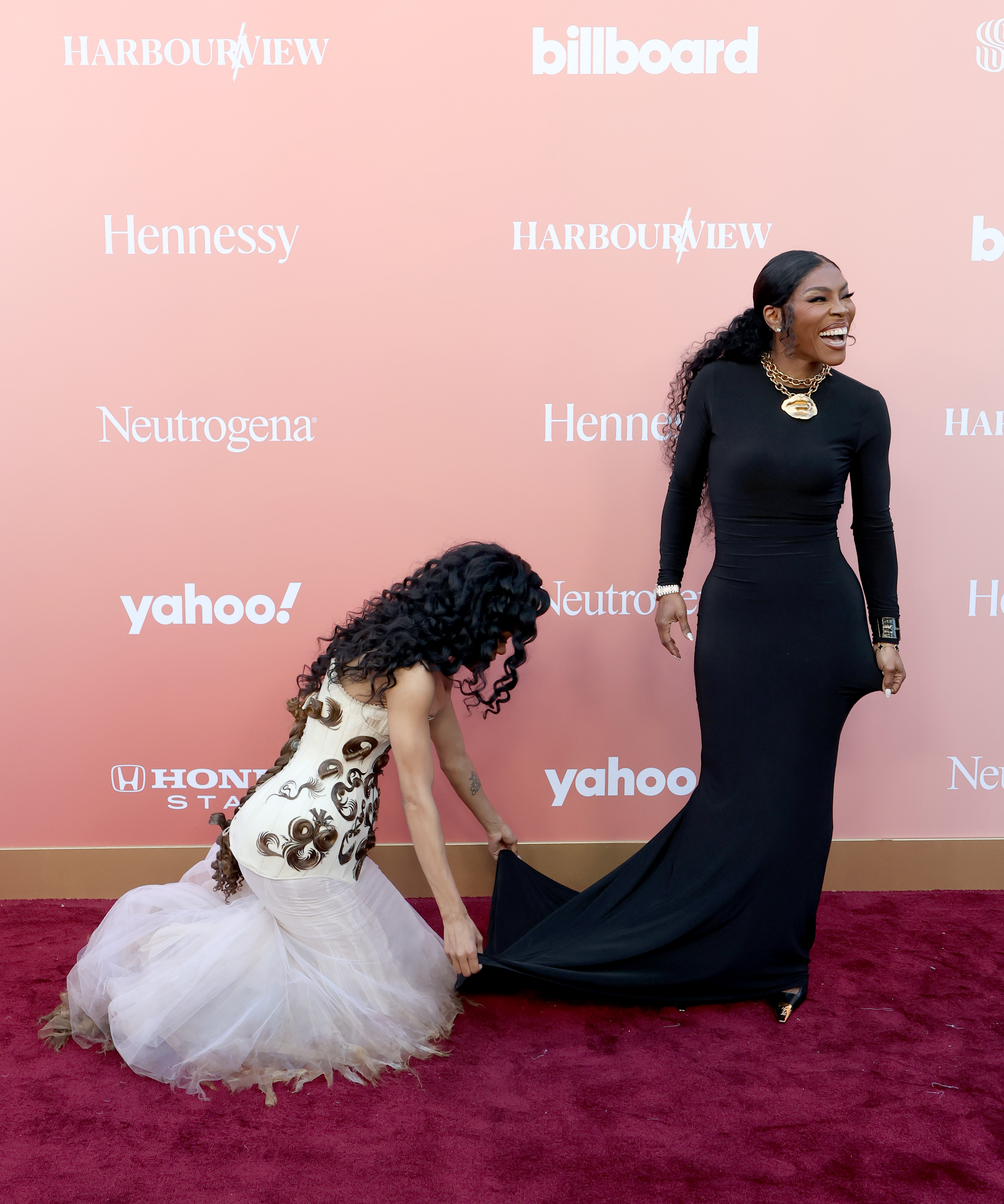 Teyana Taylor crouches to adjust Nikki's gown | Source: Getty Images