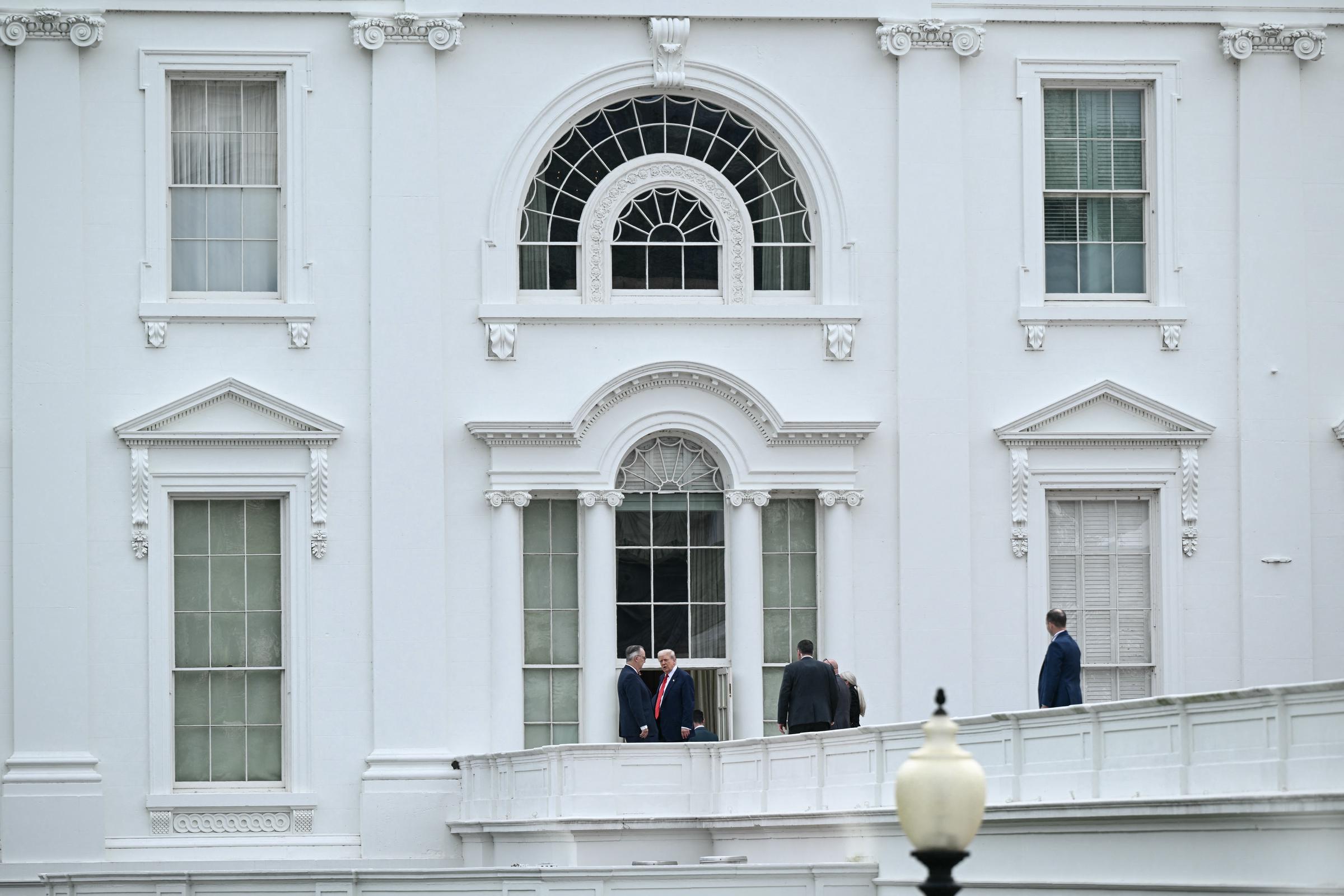 President Donald Trump surveys the White House grounds from the West Wing roof in Washington, D.C., on August 5, 2025, as security staff accompany him during what appeared to be an impromptu inspection.
