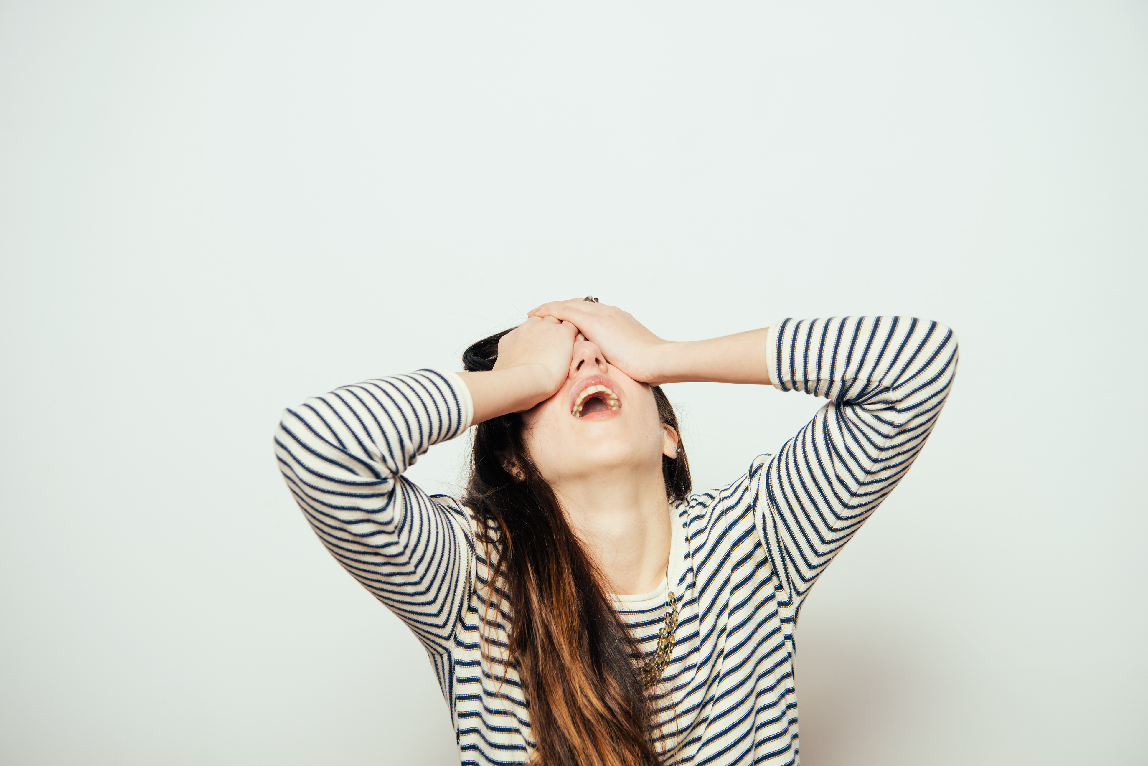Exasperated woman holding her eyes closed | Source: Shutterstock