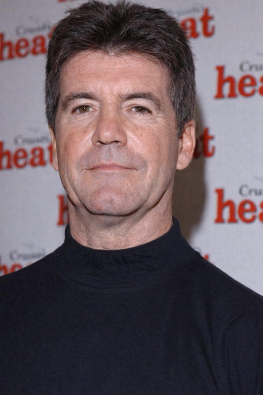 A straight-faced, close-cropped portrait against a Heat magazine step-and-repeat backdrop, with deeper lines around the mouth and a noticeably more angular jawline. | Source: ChatGPT