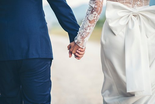 Midsection Of Couple Holding Hands While Walking Outdoors.| Photo:Getty Images.