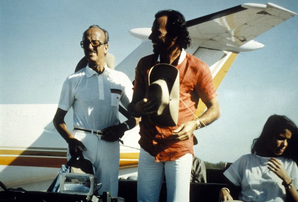 Julio Iglesias con su padre, Julio Iglesias Puga, con una avioneta en el fondo. | Foto: Getty Images