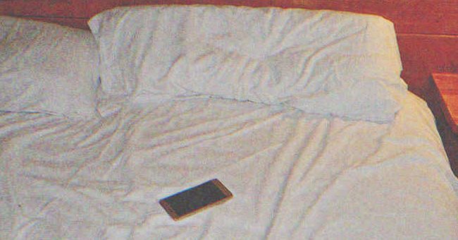 A cellphone on a bed | Source: Shutterstock