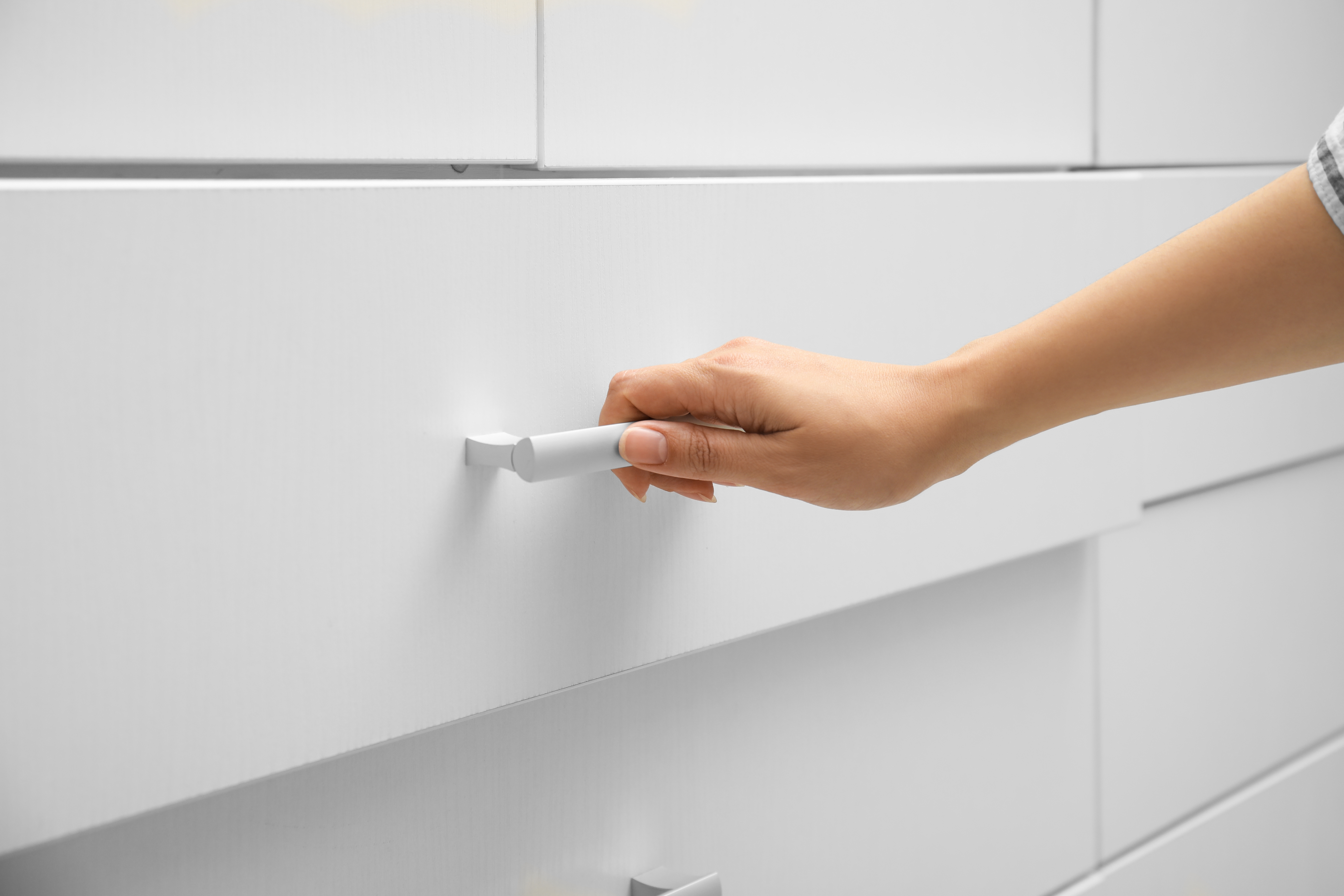 Close-up view of a woman opening a drawer at home | Source: Shutterstock