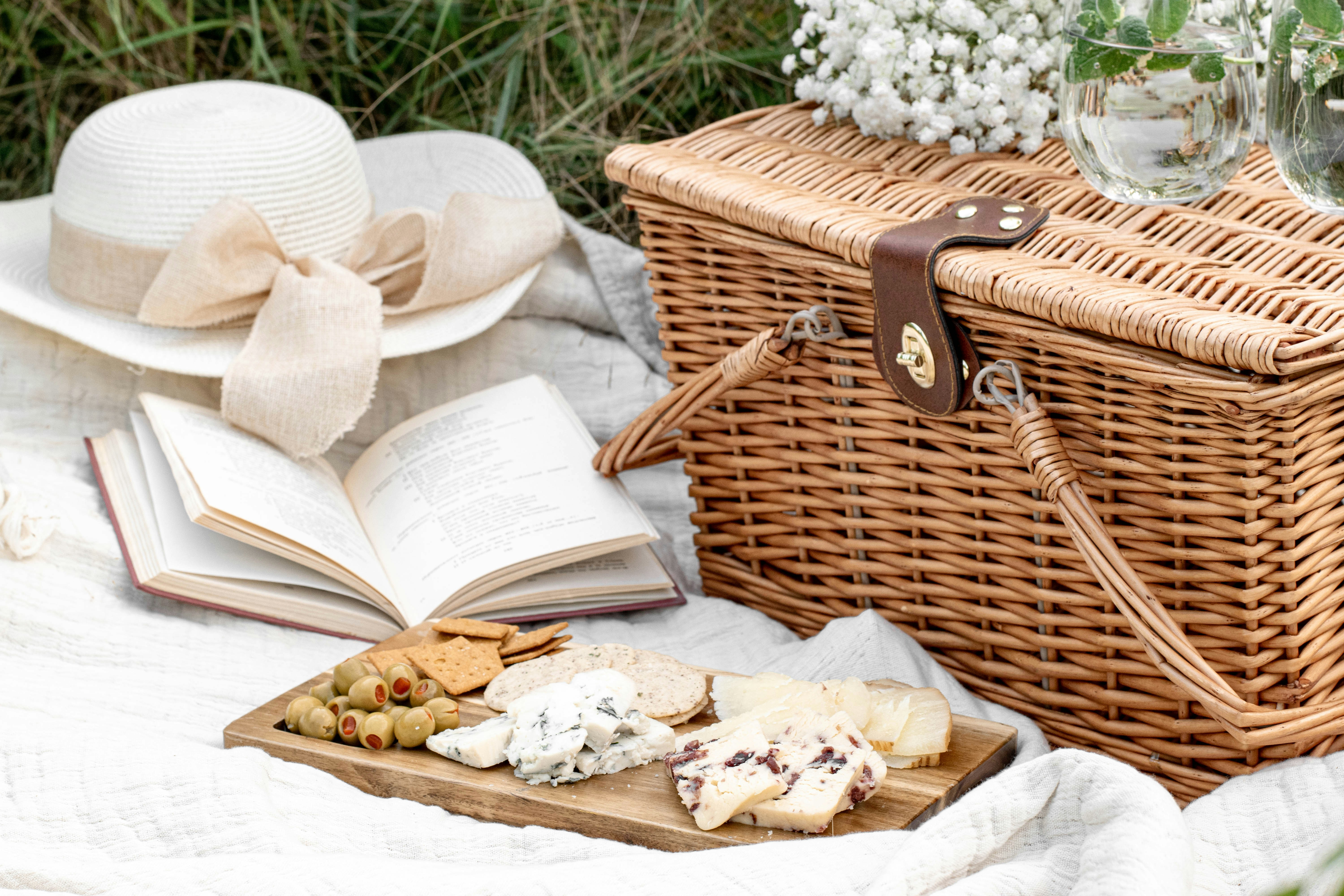 A picnic basket, food, a book, and a hat | Source: Unsplash