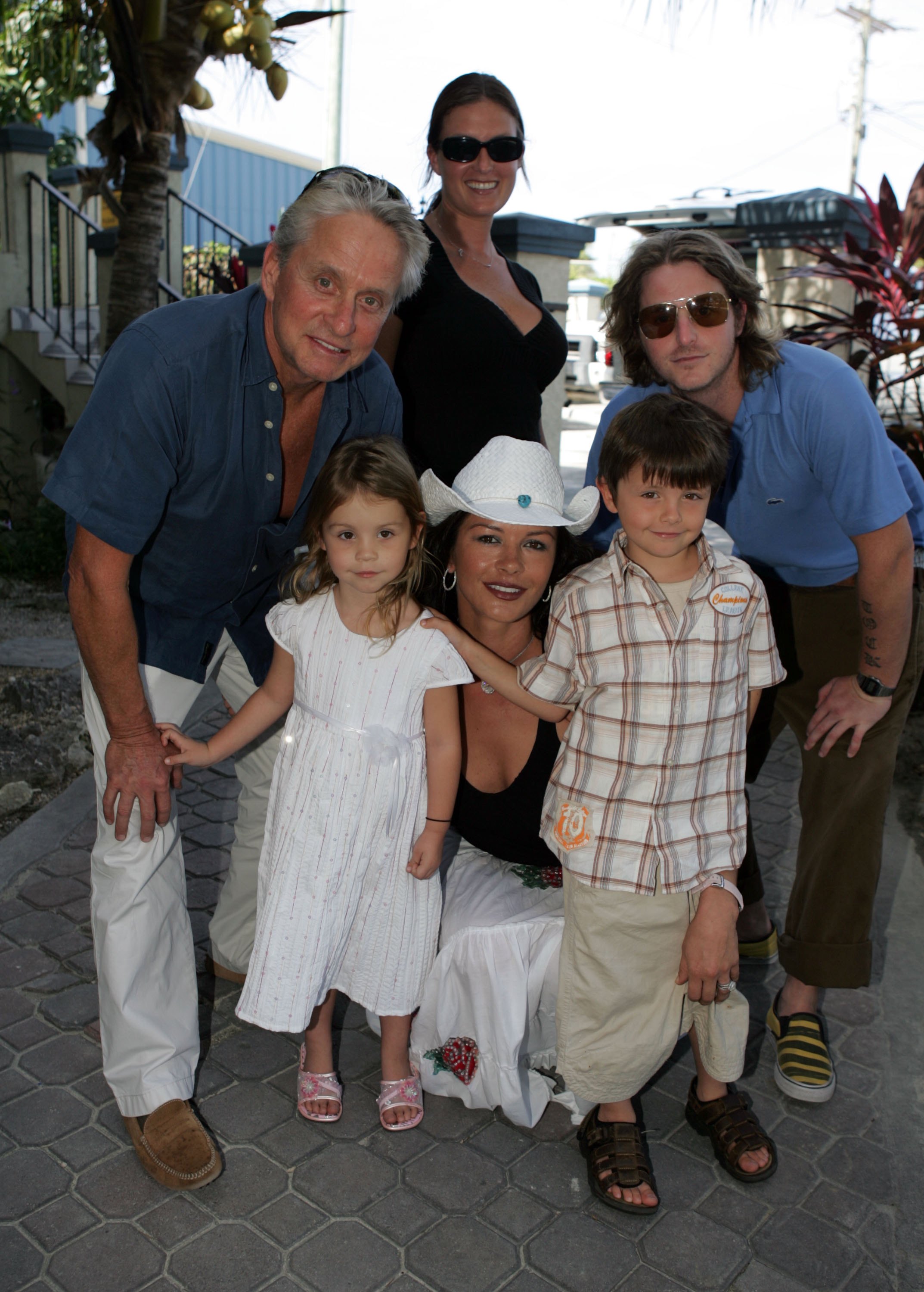 Michael Douglas and Catherine Zeta-Jones arrive at Provo Airport with their children Carys, Dylan, and Cameron Douglas with his girlfriend Kelly Sott, before traveling to Dellis Cay in the Caribbean on January 5, 2007. | Source: Getty Images