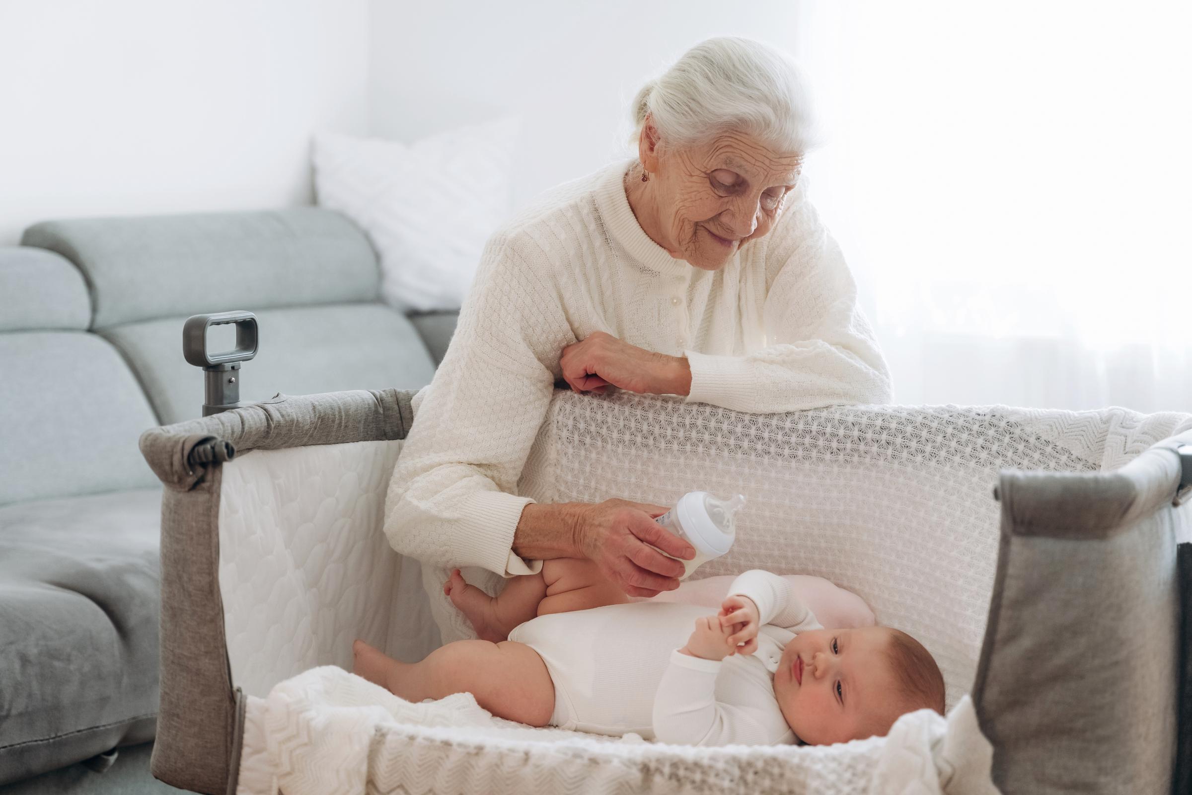Grandmother feeding her baby grandchild | Source: Shutterstock