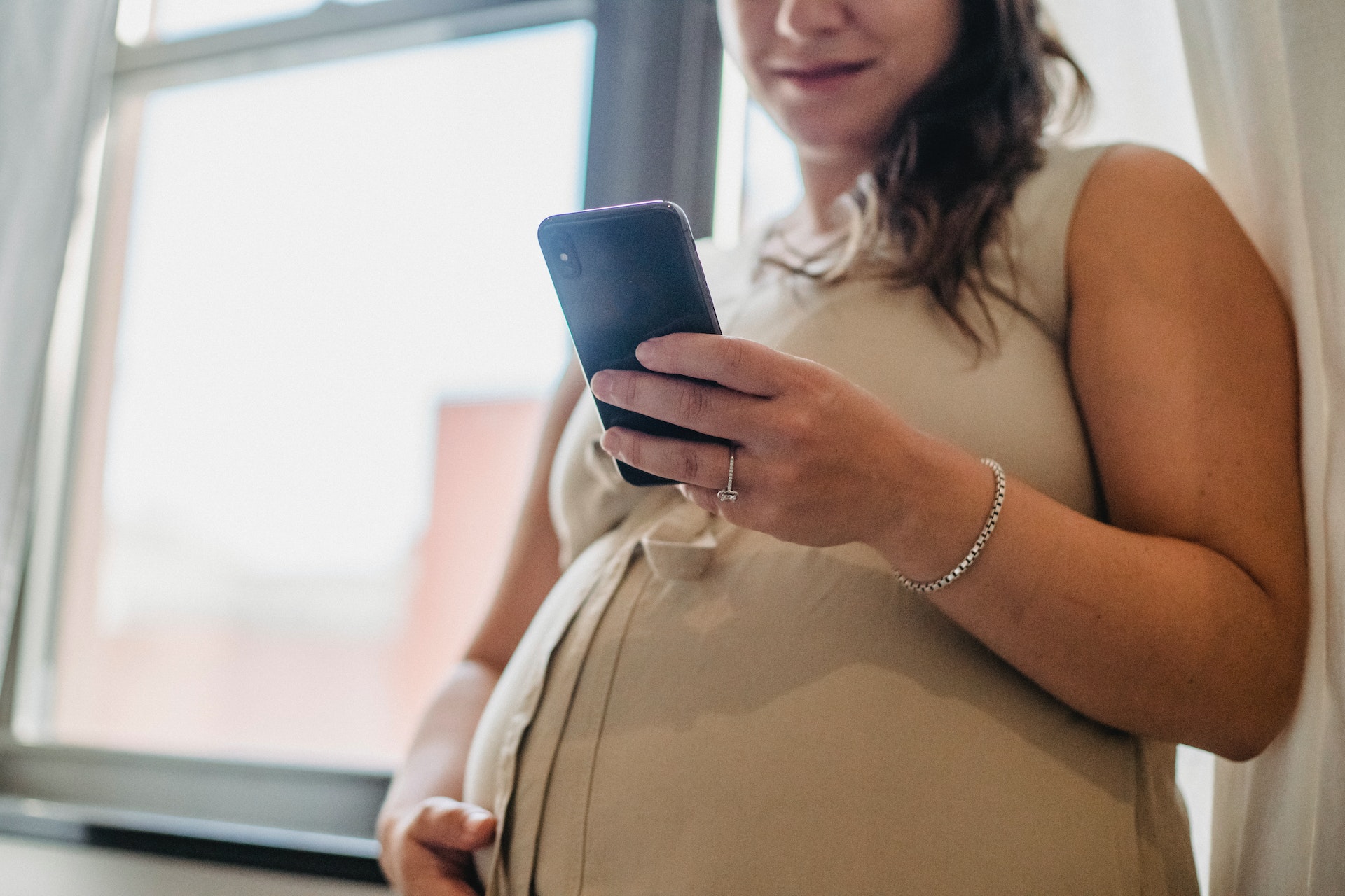 A pregnant woman using her phone | Source: Shutterstock