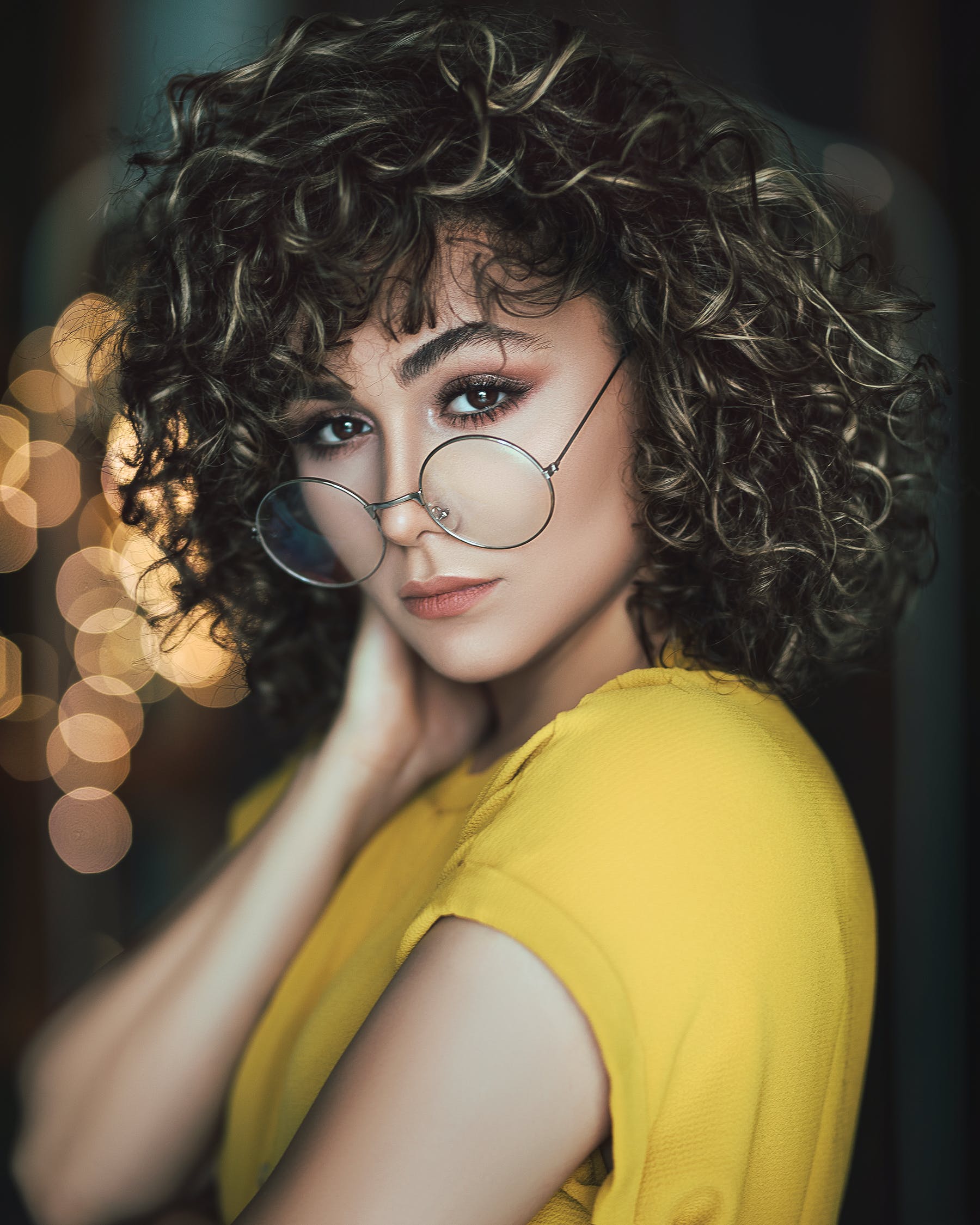 Mujer posando con sus gafas formuladas mientras sostiene su cuello. | Foto: Pexels Mujer posando con sus gafas formuladas mientras sostiene su cuello. | Foto: Pexels