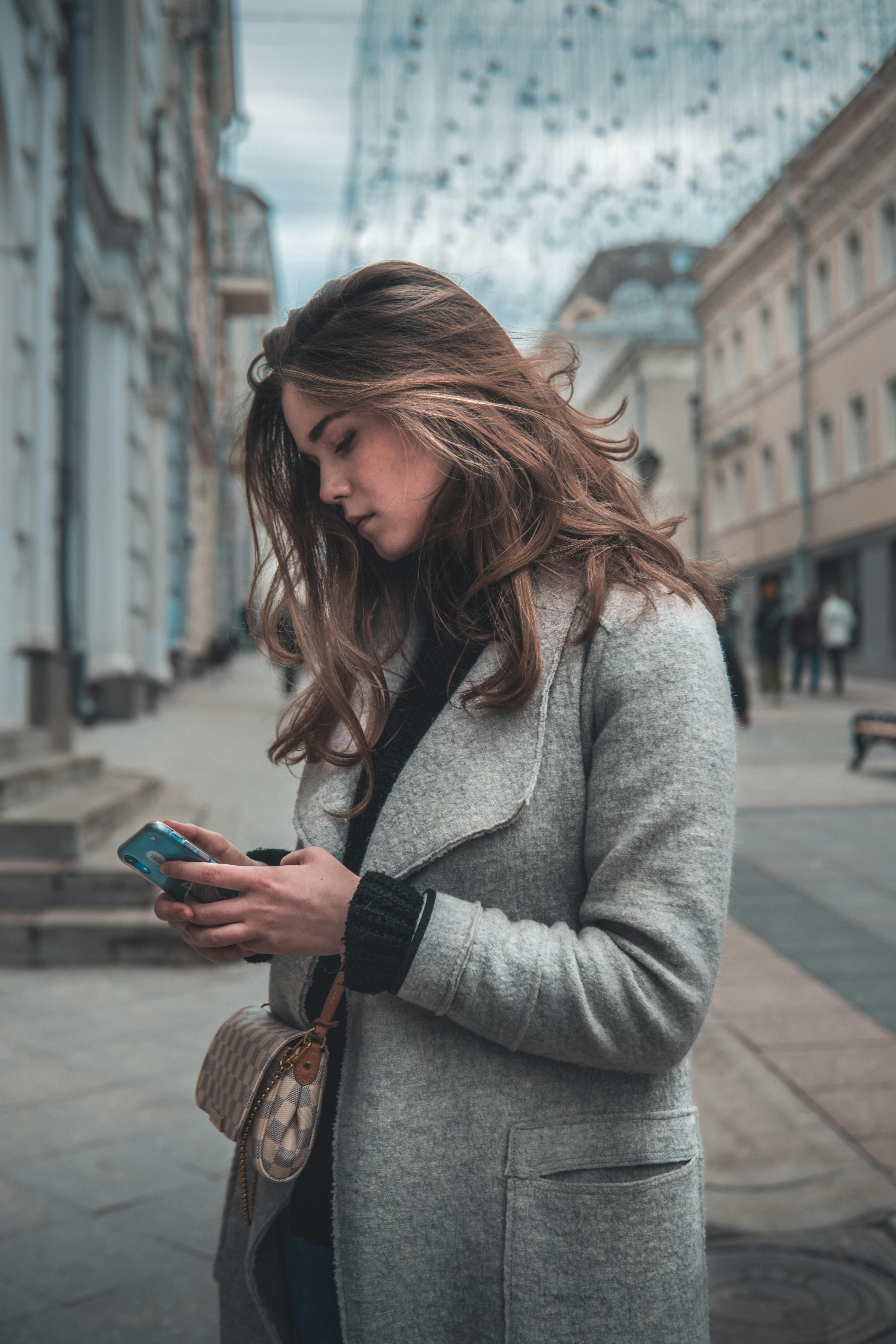 A woman on the street using her phone | Source: Pexels