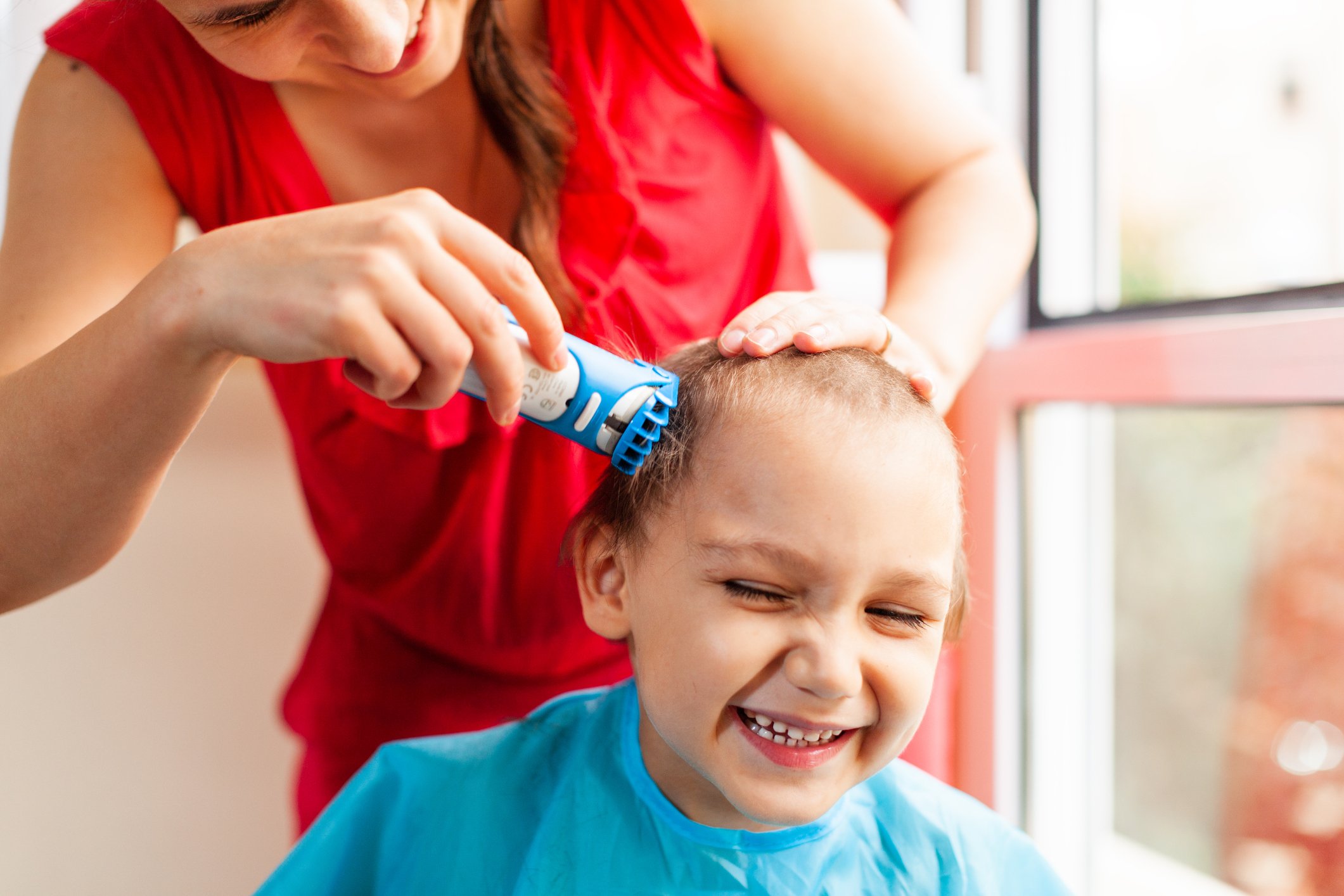 Mother trimming toddlers hair  | Photo: Getty Images