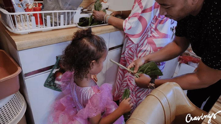 Luna Stephens helps her father, John Legend, at his grandma's house | Source: YouTube/Chrissy Teigen