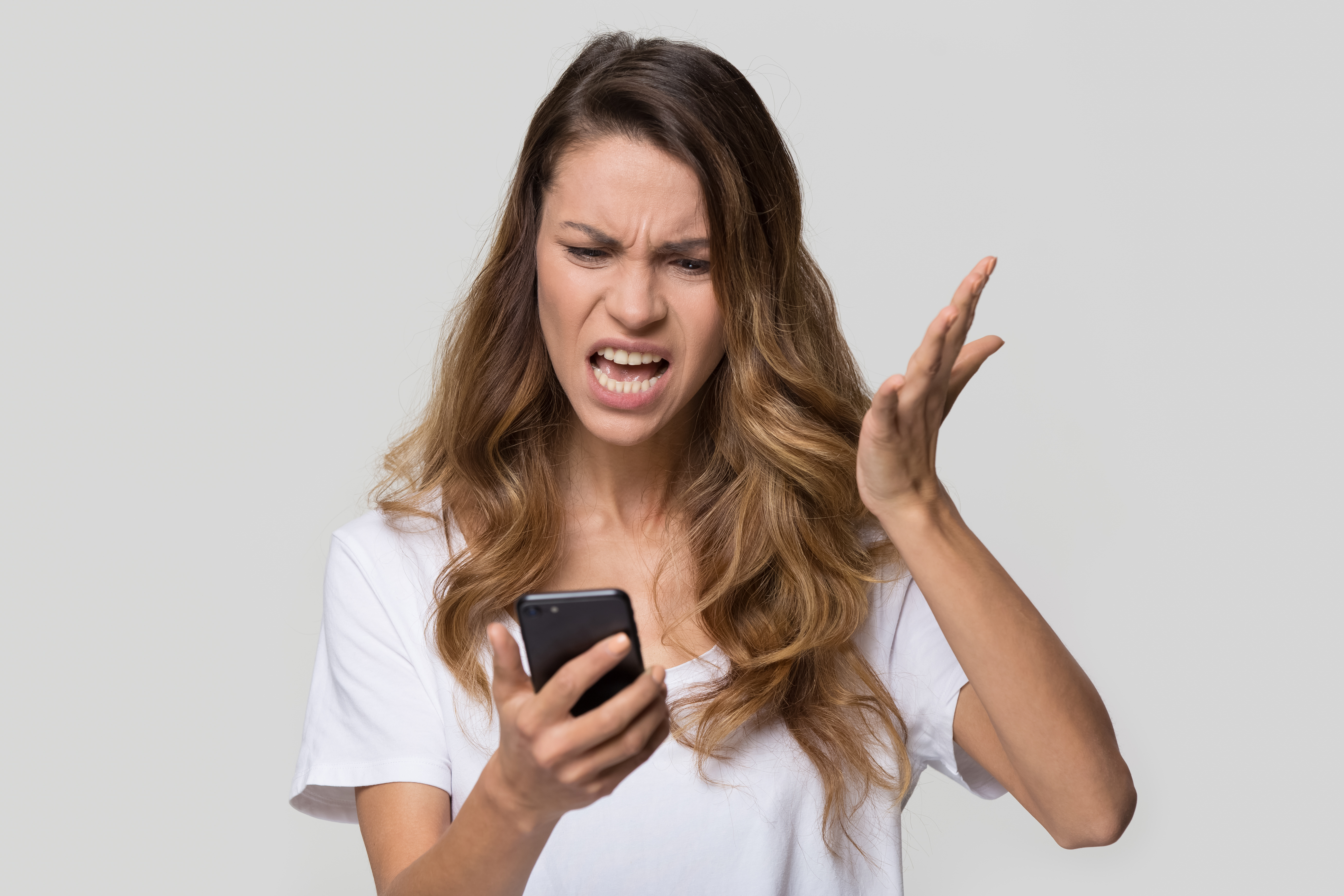An angry woman looking at her phone | Source: Shutterstock