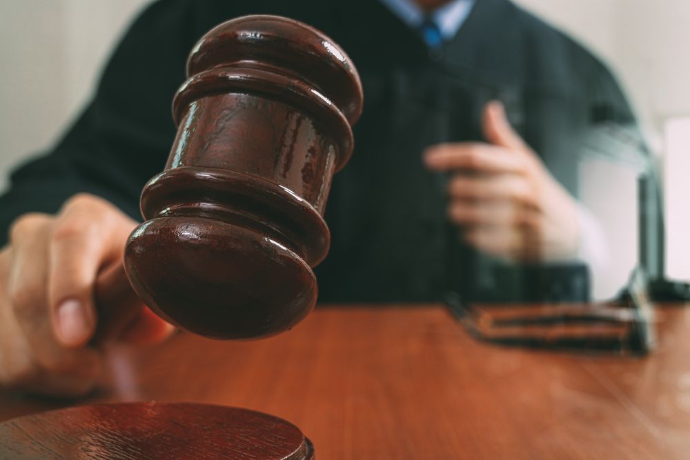 A judge striking a gavel against a sound block. | Source: Shutterstock