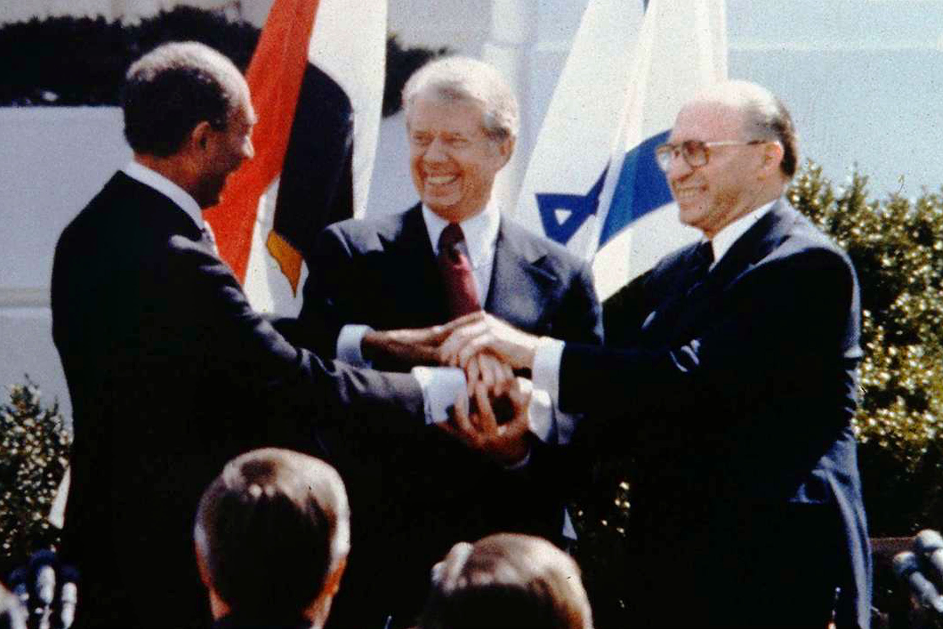 The triple handshake between Egyptian President Anwar Sadat (L), U.S. President Jimmy Carter (C) and Israeli Prime Minister Menahem Begin on March 26, 1979, on the White House lawn in Washington D.C. | Source: Getty Images