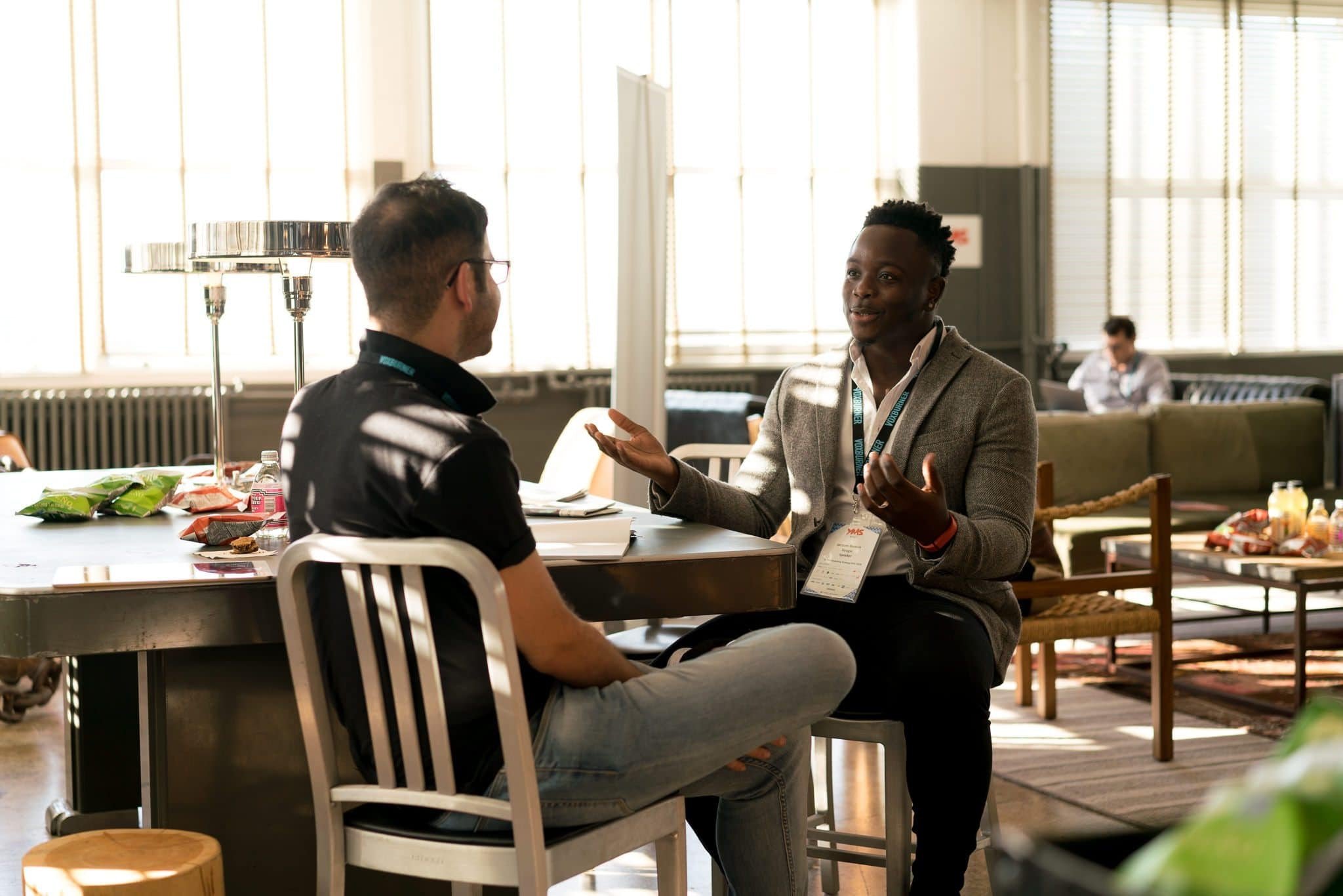 Man gesturing to another man as they sit across from each other | Photo: Pexels