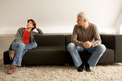Photo of father and son having a discussion on a couch | Photo: Getty Images
