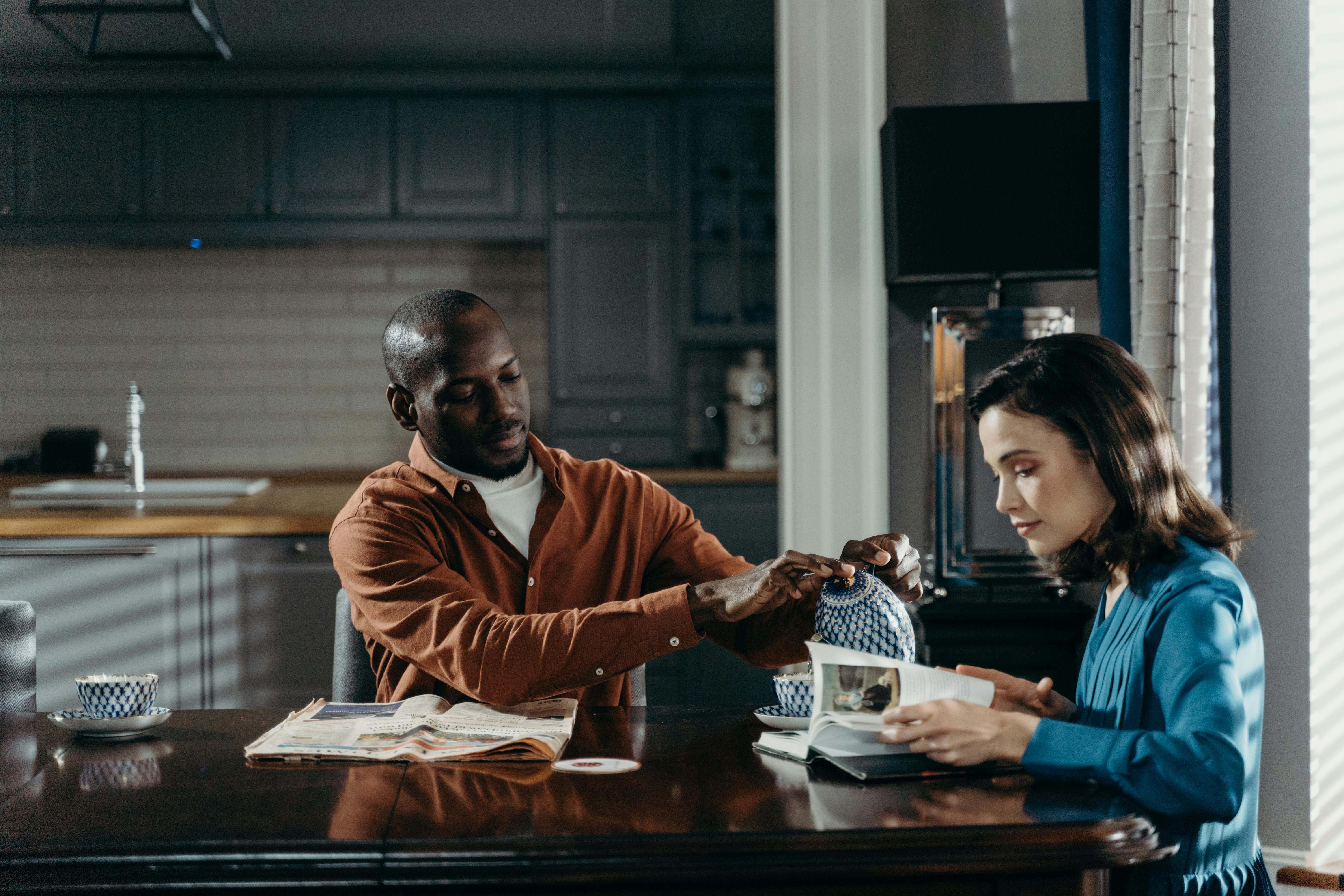An elegant couple drinking coffee in the kitchen | Source: Pexels