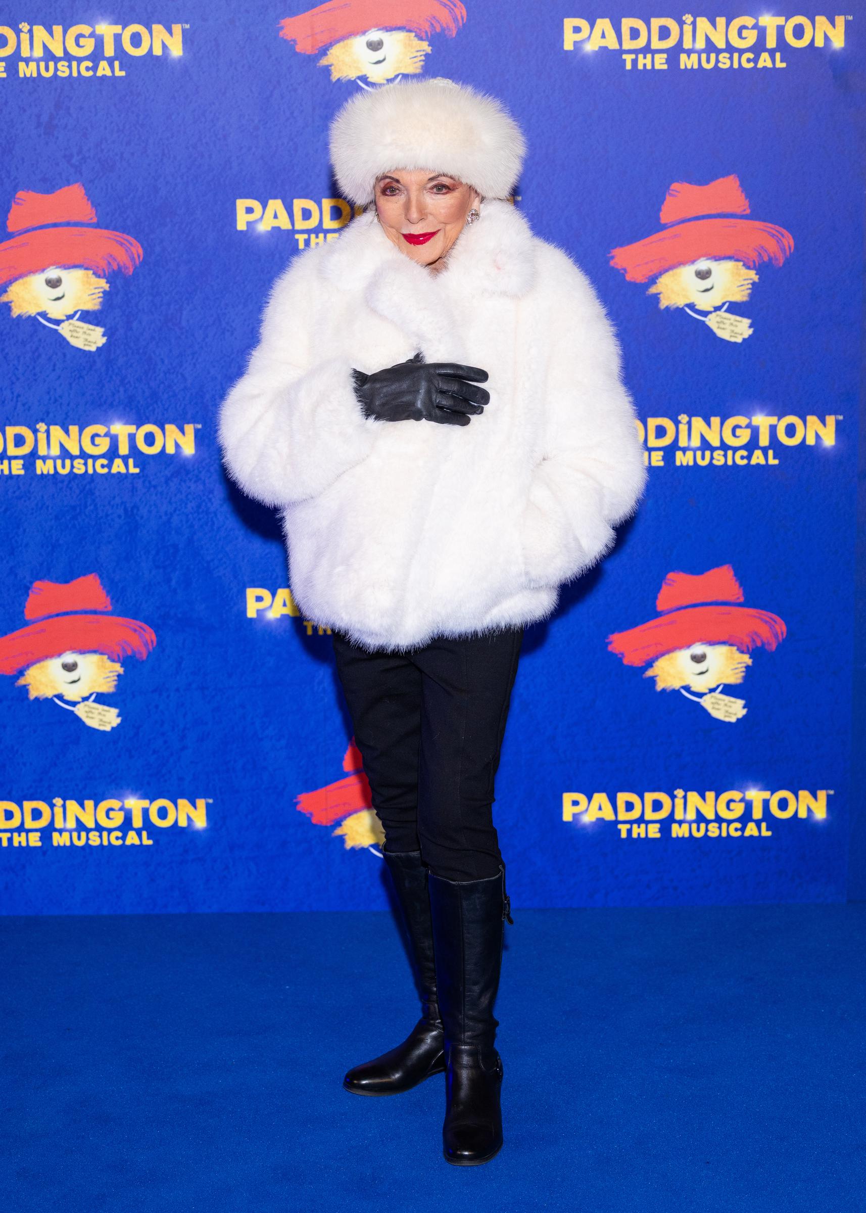 Framed against the musical’s vivid backdrop, she posed with one hand tucked into her pocket, the other lightly touching her collar, adding a playful touch to the otherwise regal look. Her charm and command of the spotlight remained undimmed.