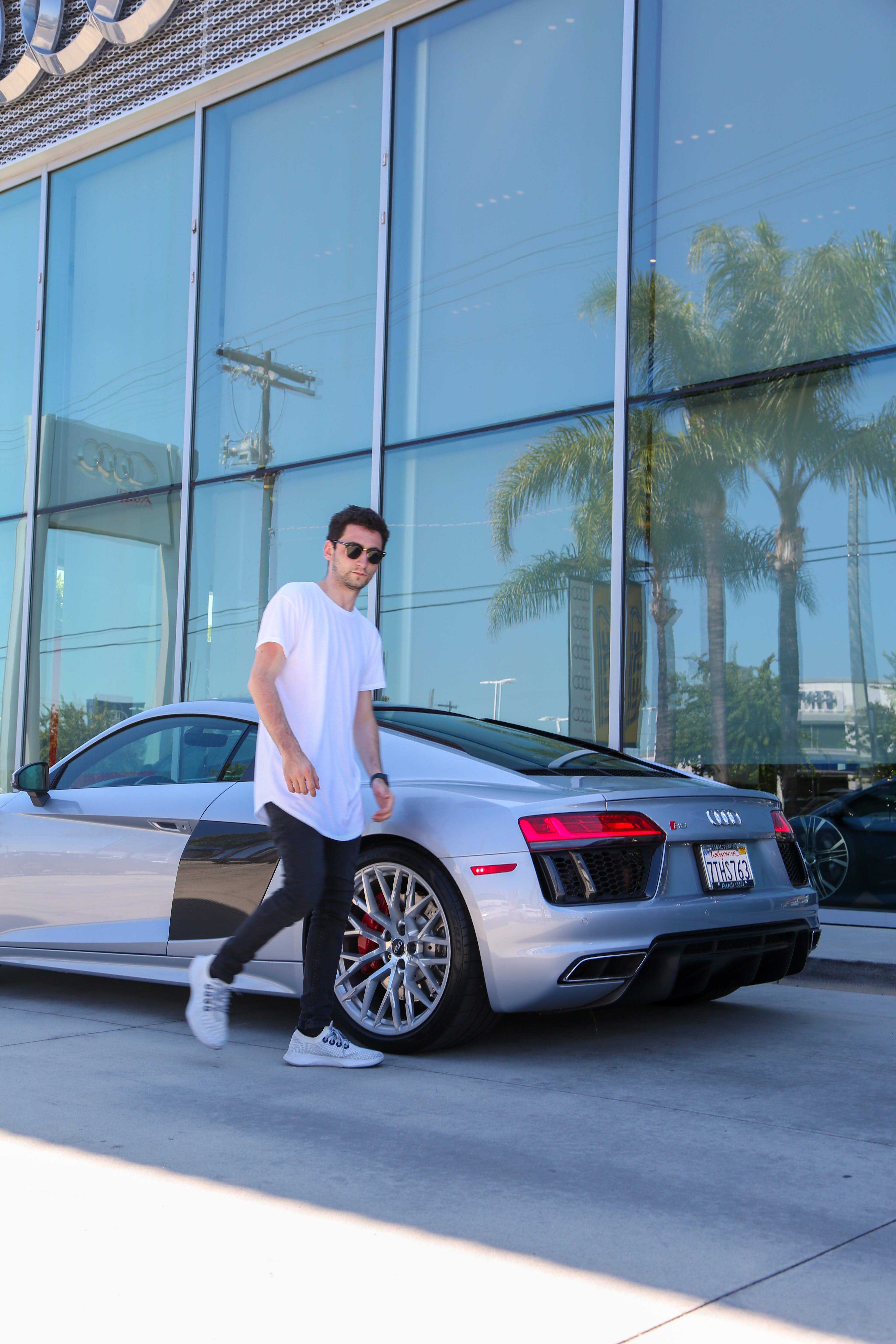 A young man standing next to an expensive car. | Source: Pexels