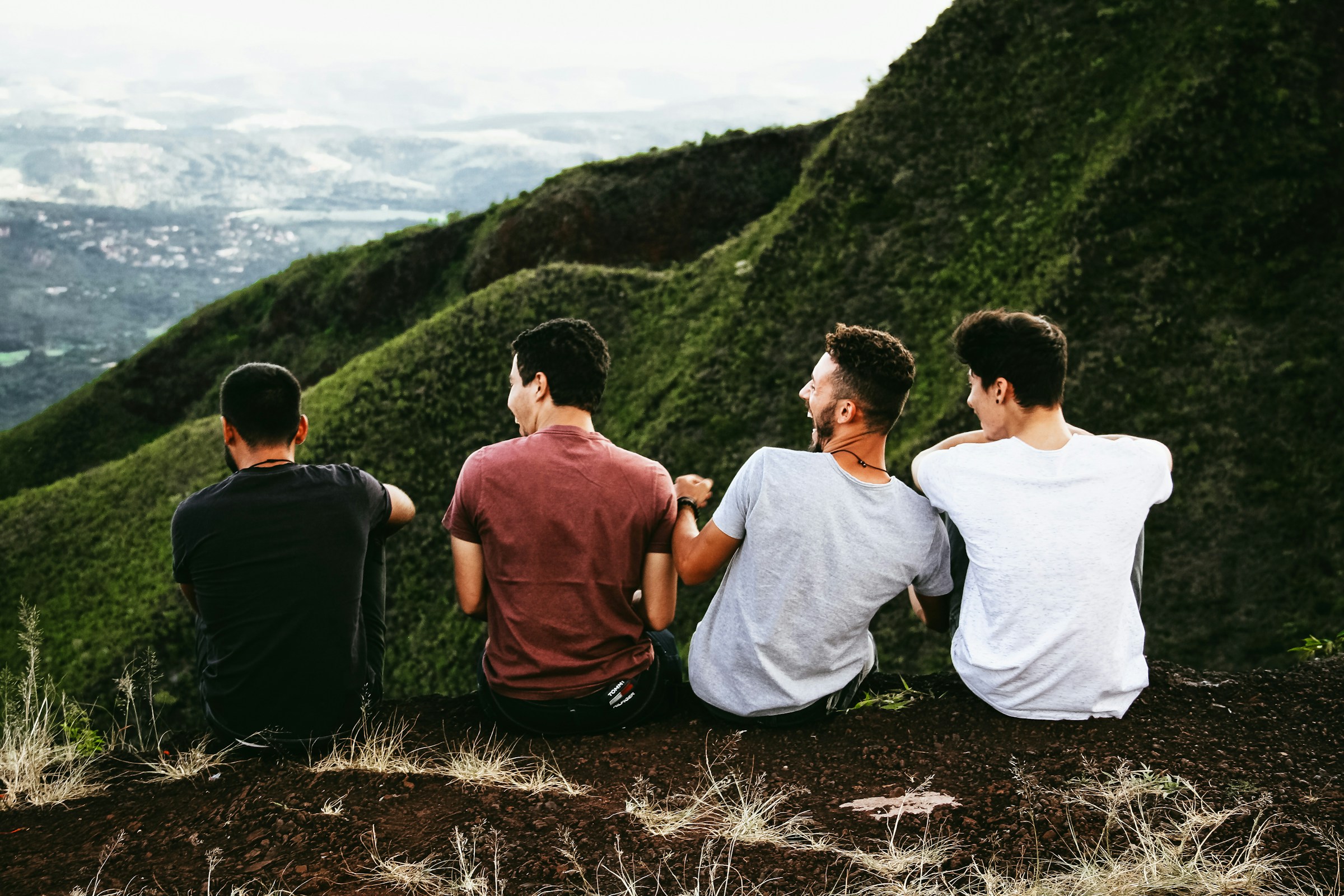 Four young men sitting on a mountain trail | Source: Unsplash