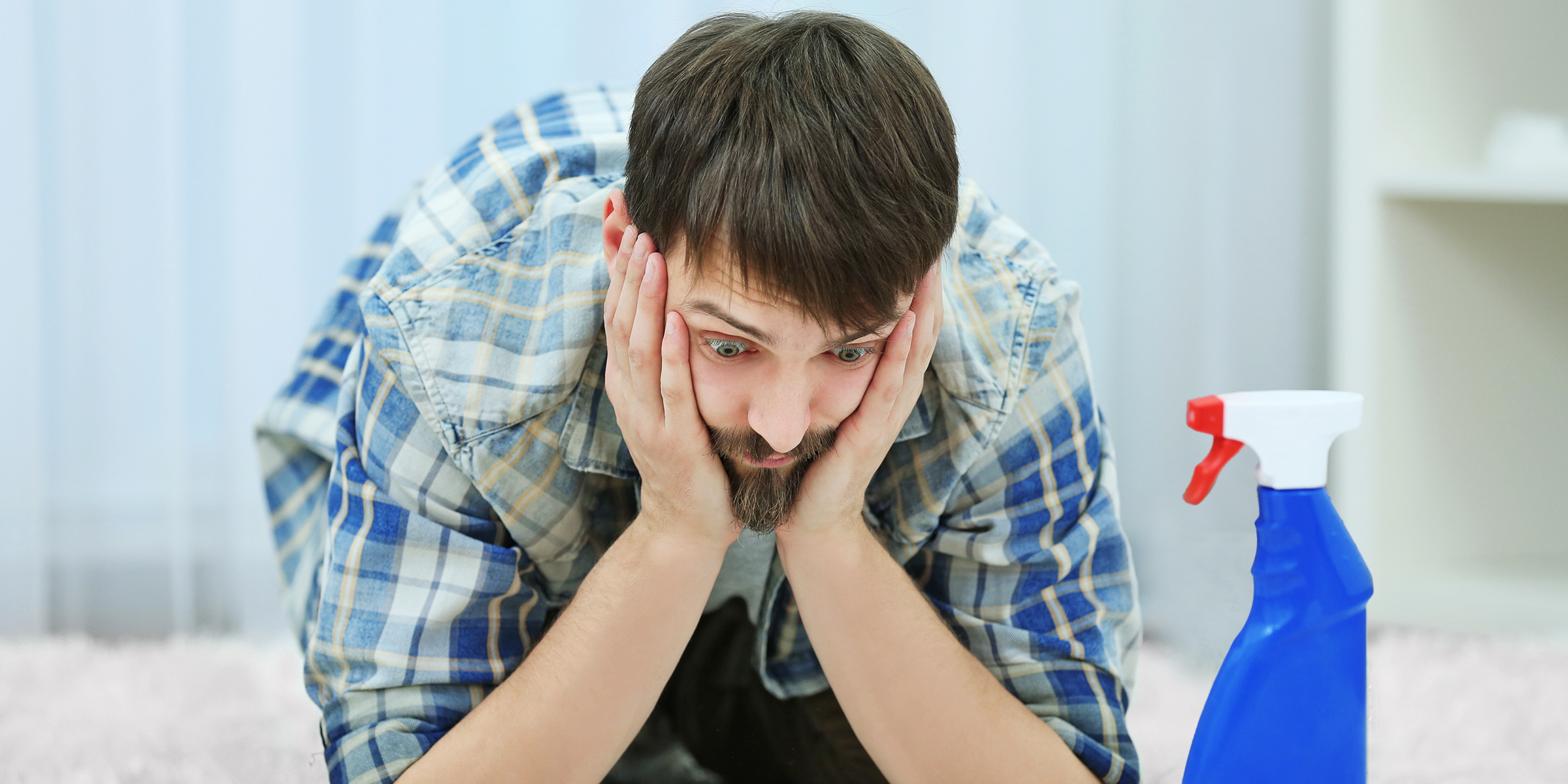 A confused man seeing a bottle of cleaner | Source: Shutterstock