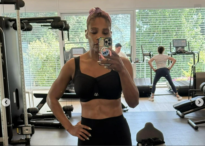 Serena Williams took another mirror selfie from a slightly different angle, keeping her posture upright with her hand resting at her waist. The same all-black outfit highlighted her defined physique against a backdrop of treadmills and greenery outside the window.