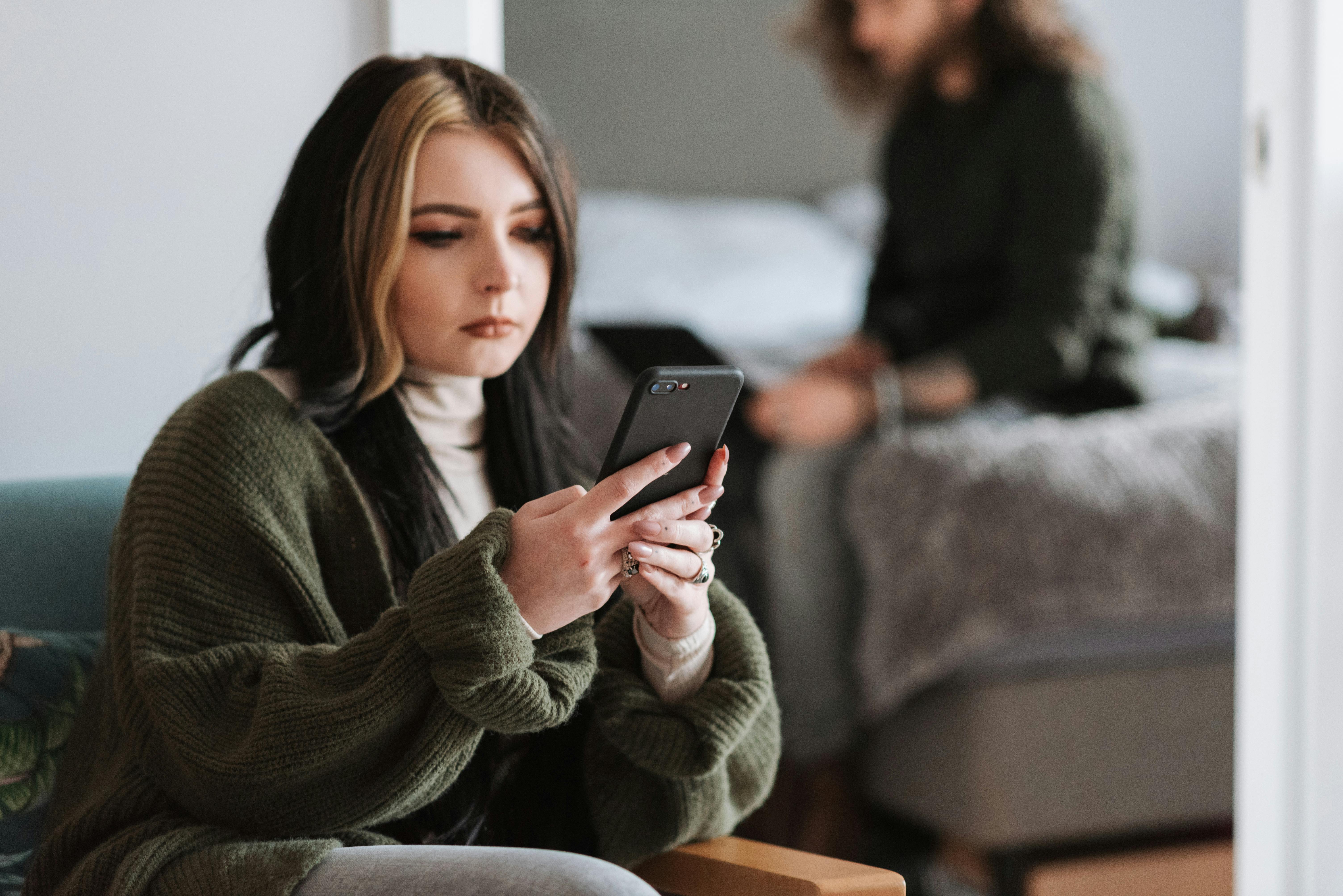 A woman scrolling through her phone | Source: Pexels