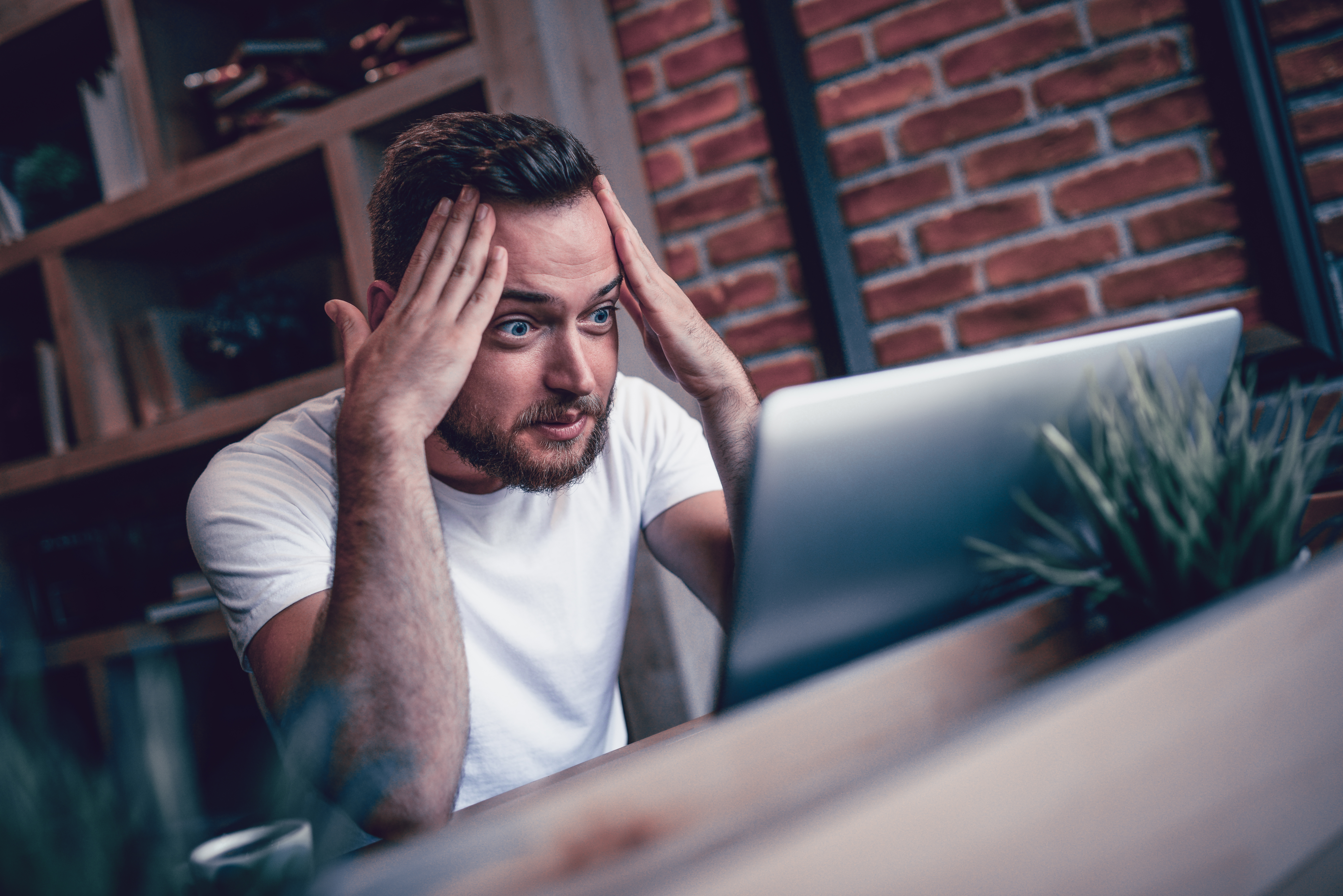 Shocked Freelancer in Disbelief Working at his Favorite Coffee Place | Source: Getty Images