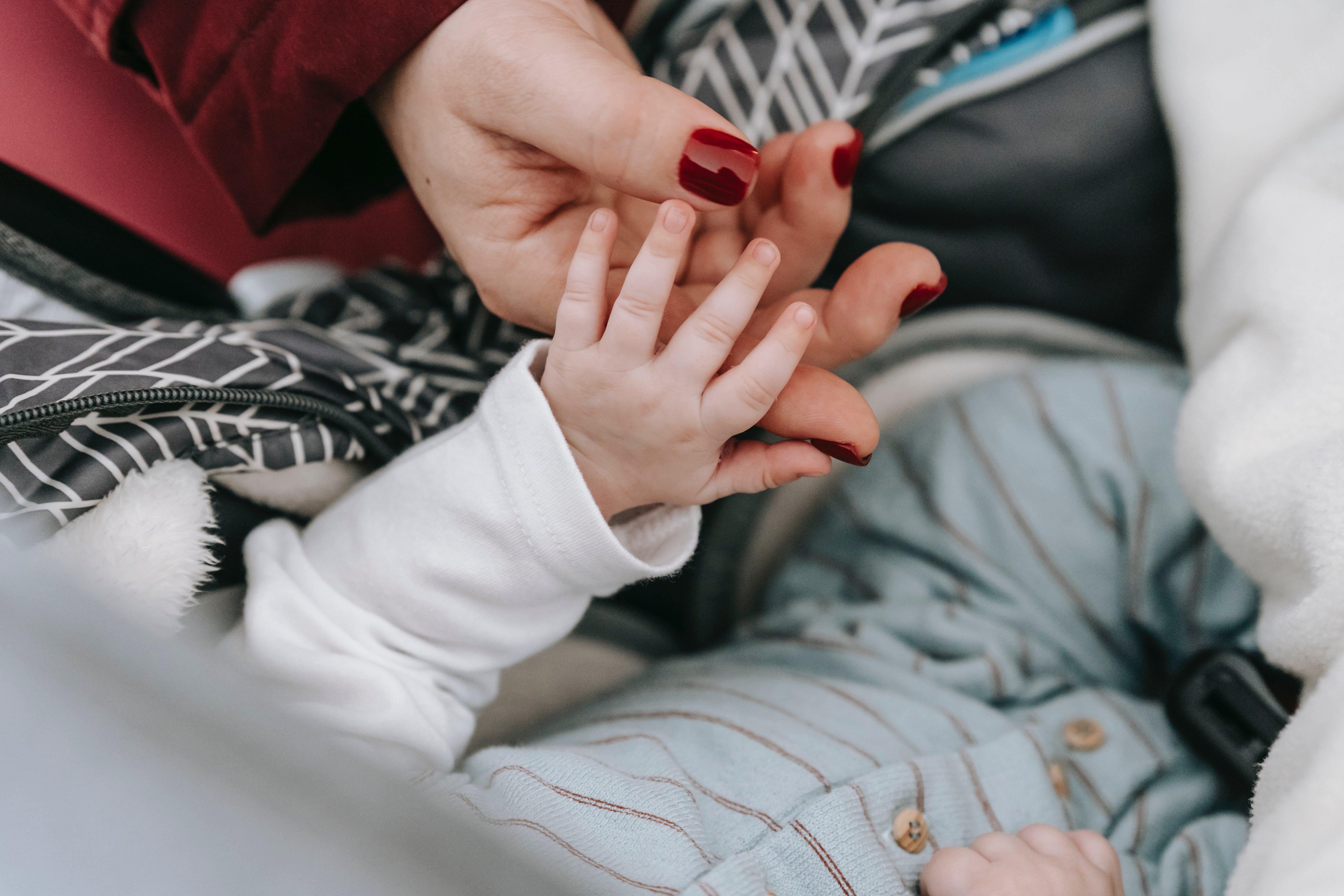 Una mujer sosteniendo la mano de un bebé. | Foto: Pexels