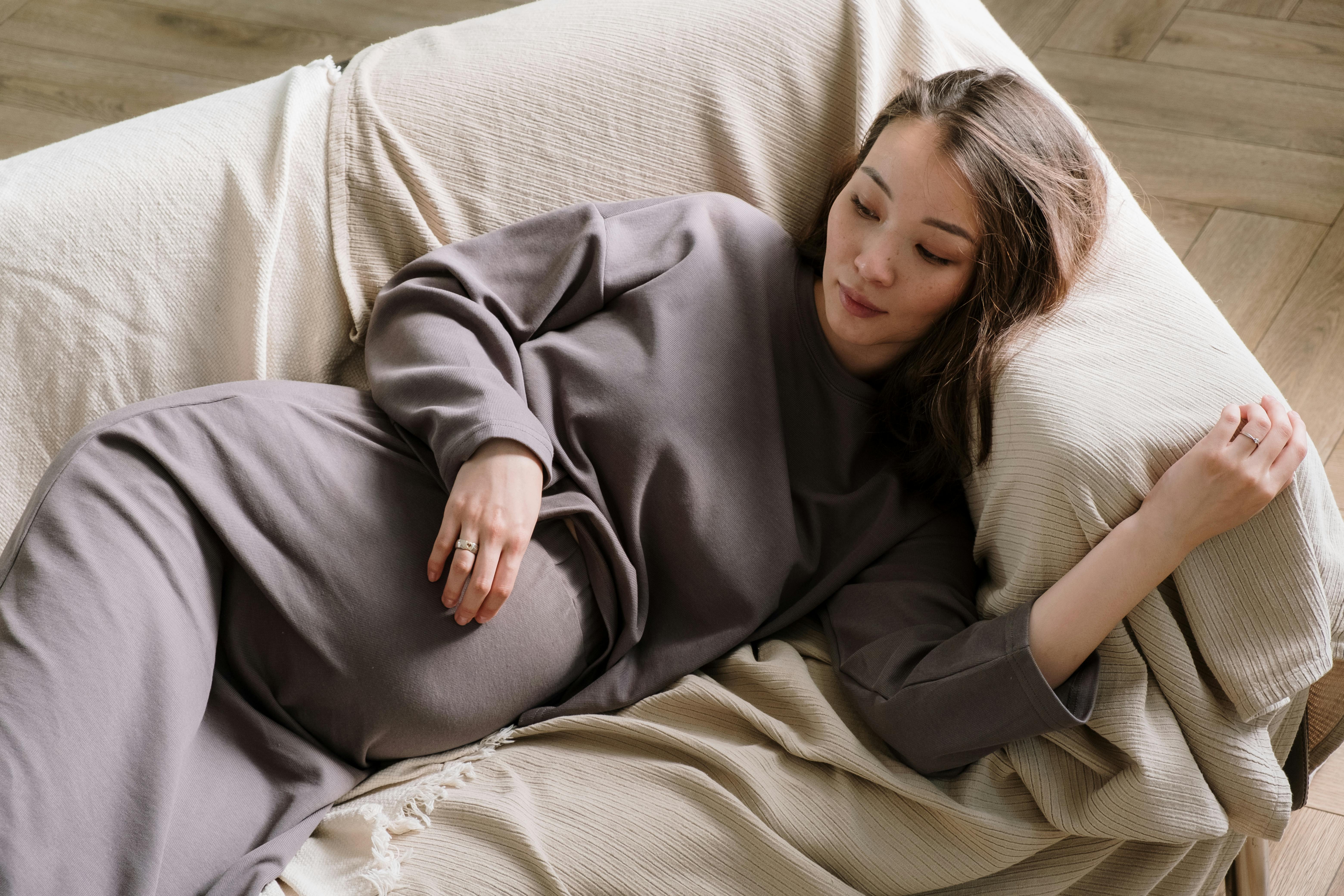 A pregnant woman lying on a couch | Source: Pexels