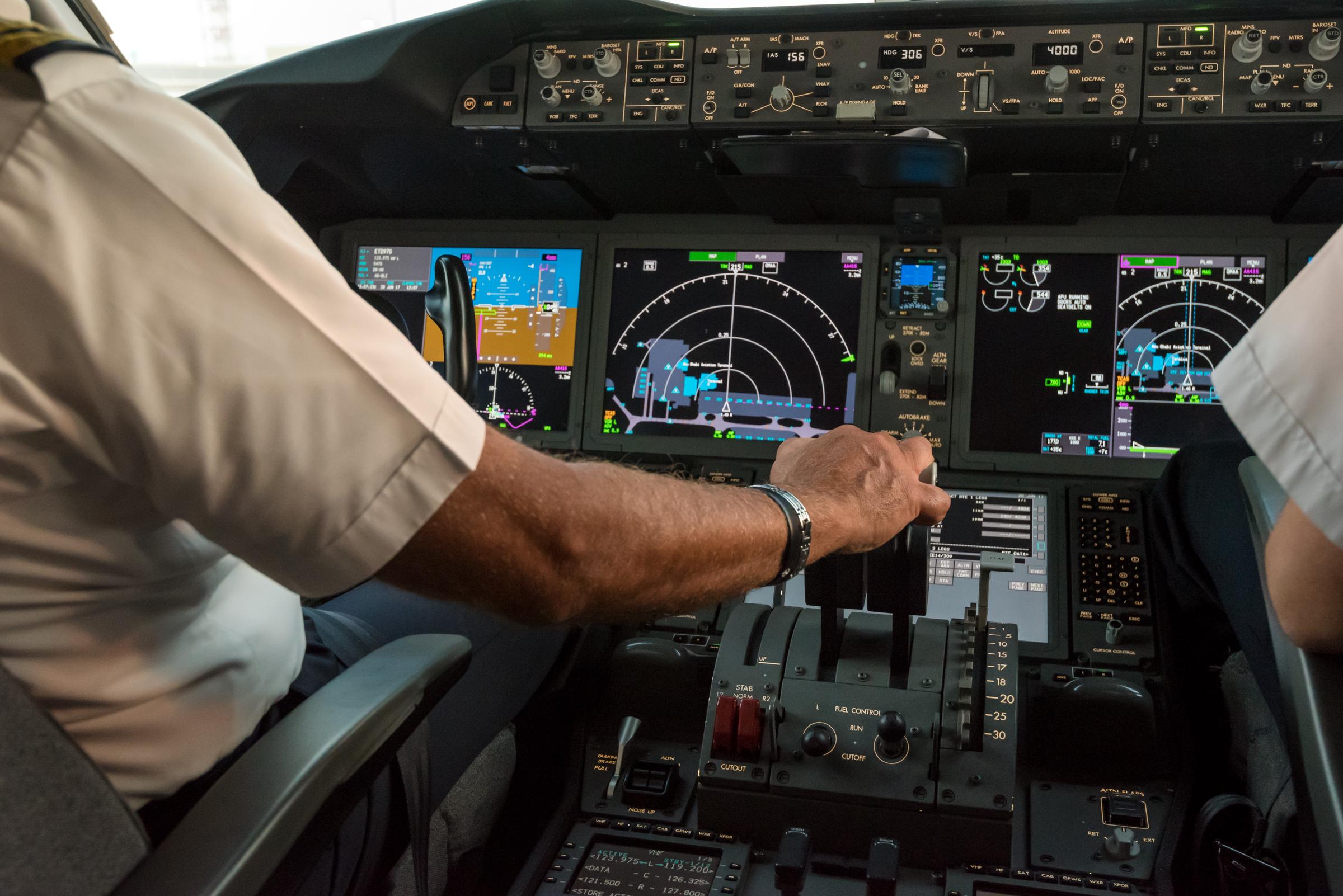 Cockpit interior of a commercial jet aircraft with the pilots’ arms visible. | Source: Getty Images