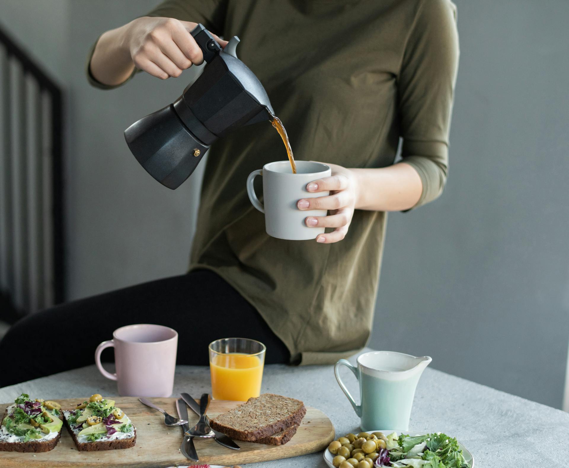 A closeup of a woman pouring coffee in a mug | Source: Pexels