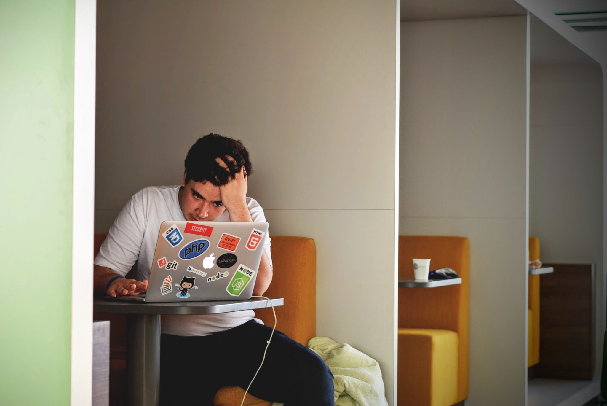 A frustrated man holding his hair while on his laptop. | Photo: Pexels.