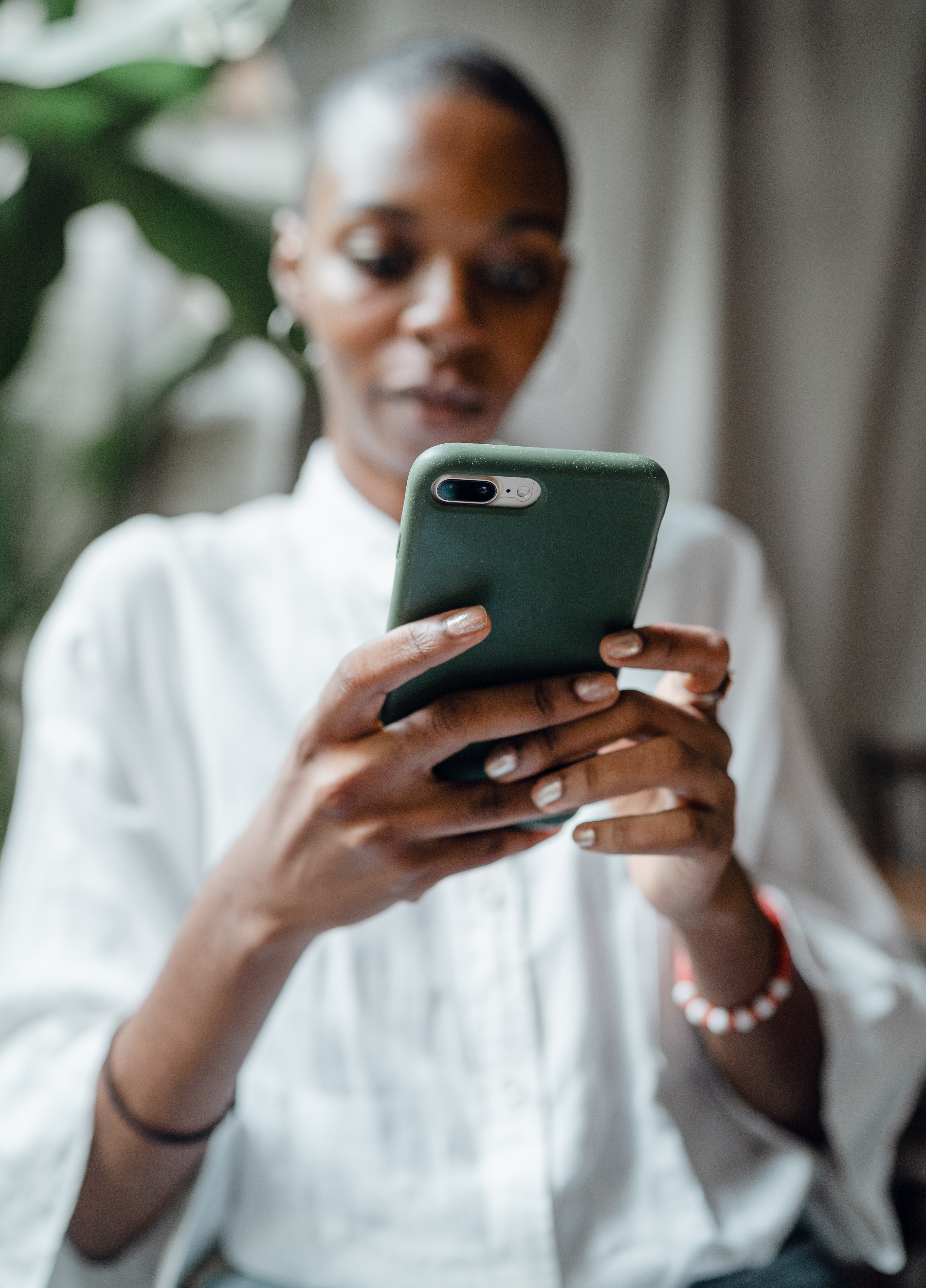 Black woman reading messages on phone | Source: Pexels