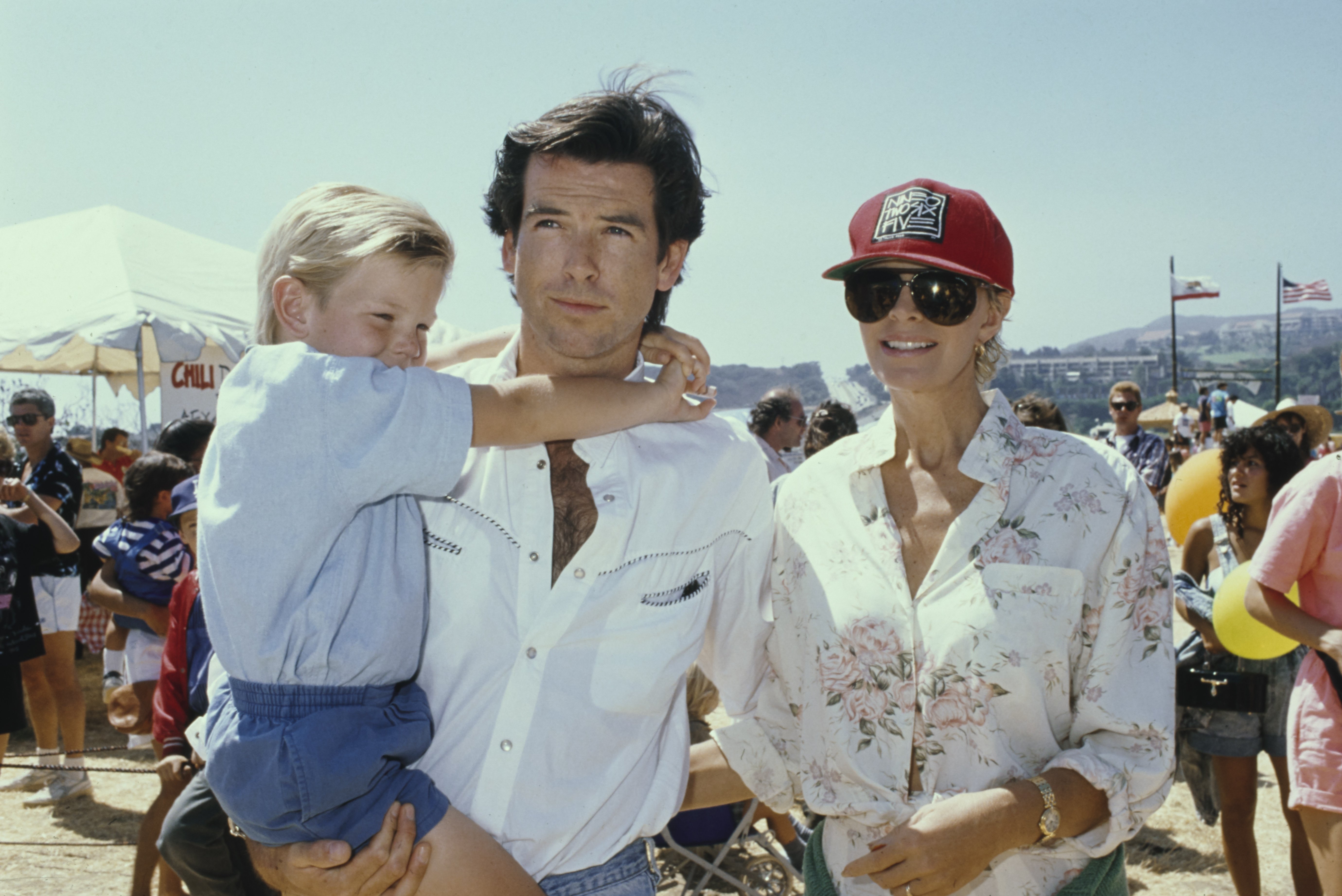 Irish actor Pierce Brosnan with his wife, Australian actress Cassandra Harris and son Sean at the 8th Annual Malibu Kiwanis Chili Cook-off Carnival & Fair, at the Civic Center Area in Malibu, California, 2nd September 1989. | Source: Getty Images