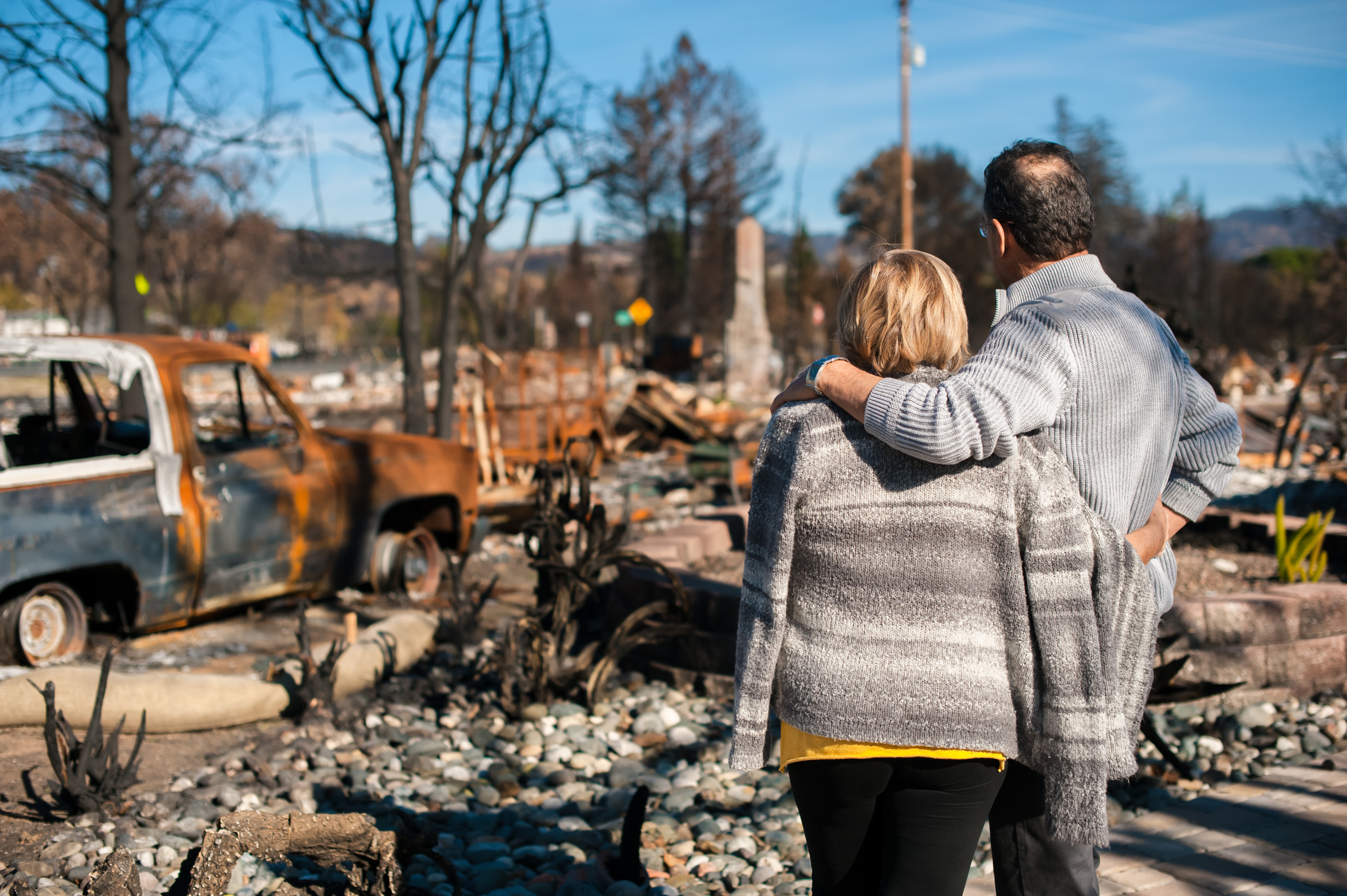 Couple looking at burned home | Source: Getty Images