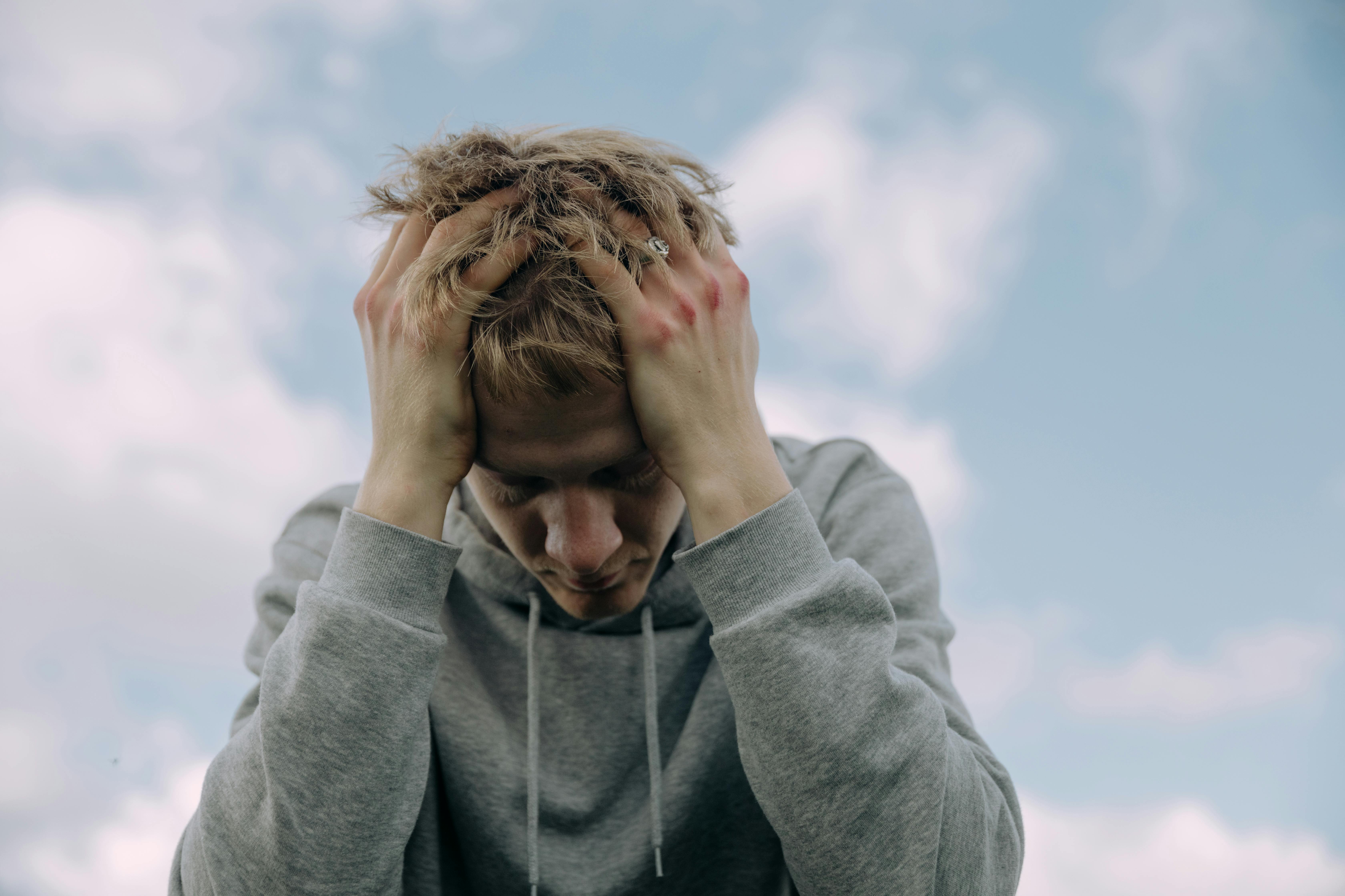 A frustrated man running his hands through his hair | Source: Pexels