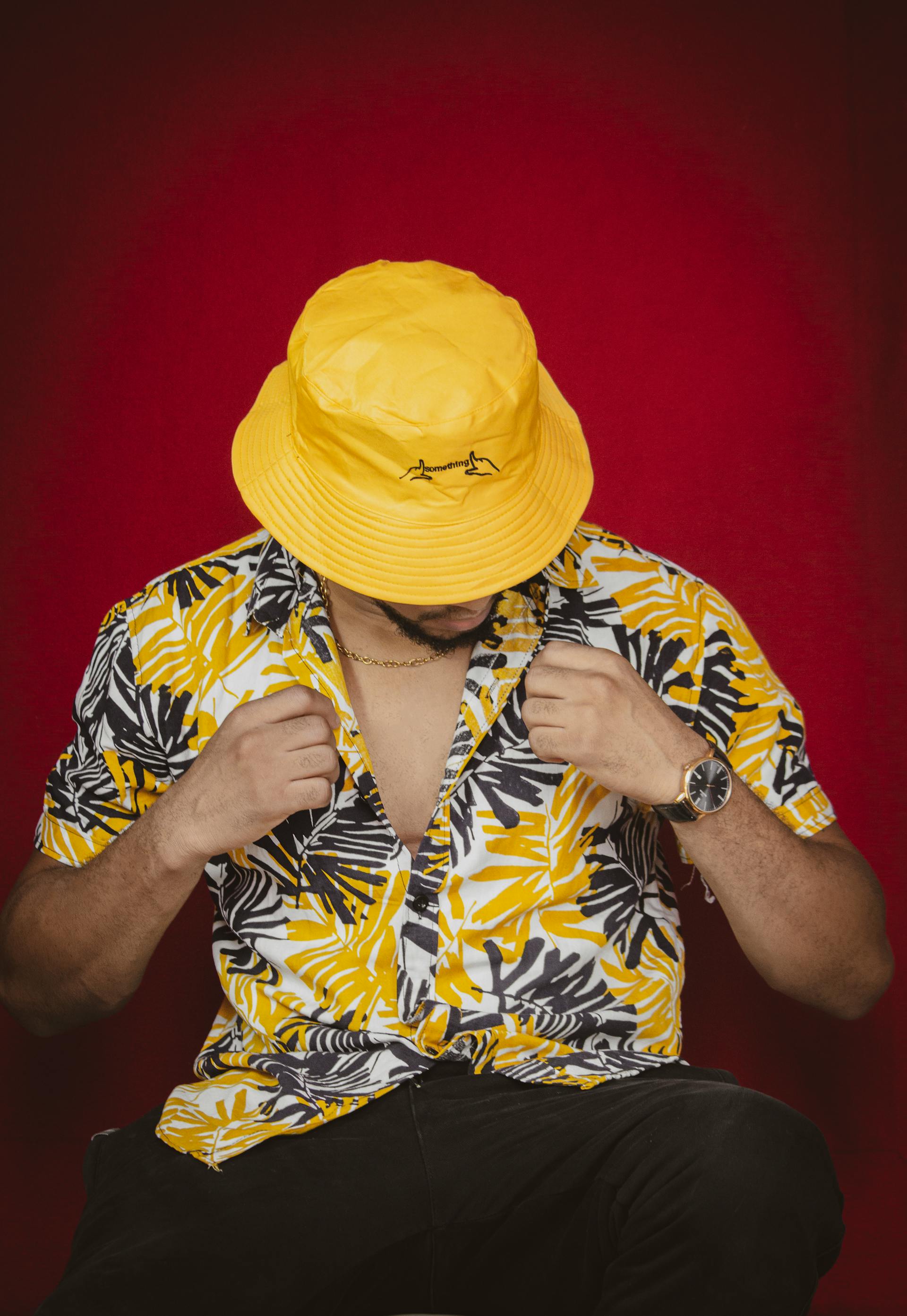 A man in a yellow Hawaiian shirt wearing a matching bucket hat | Source: Pexels