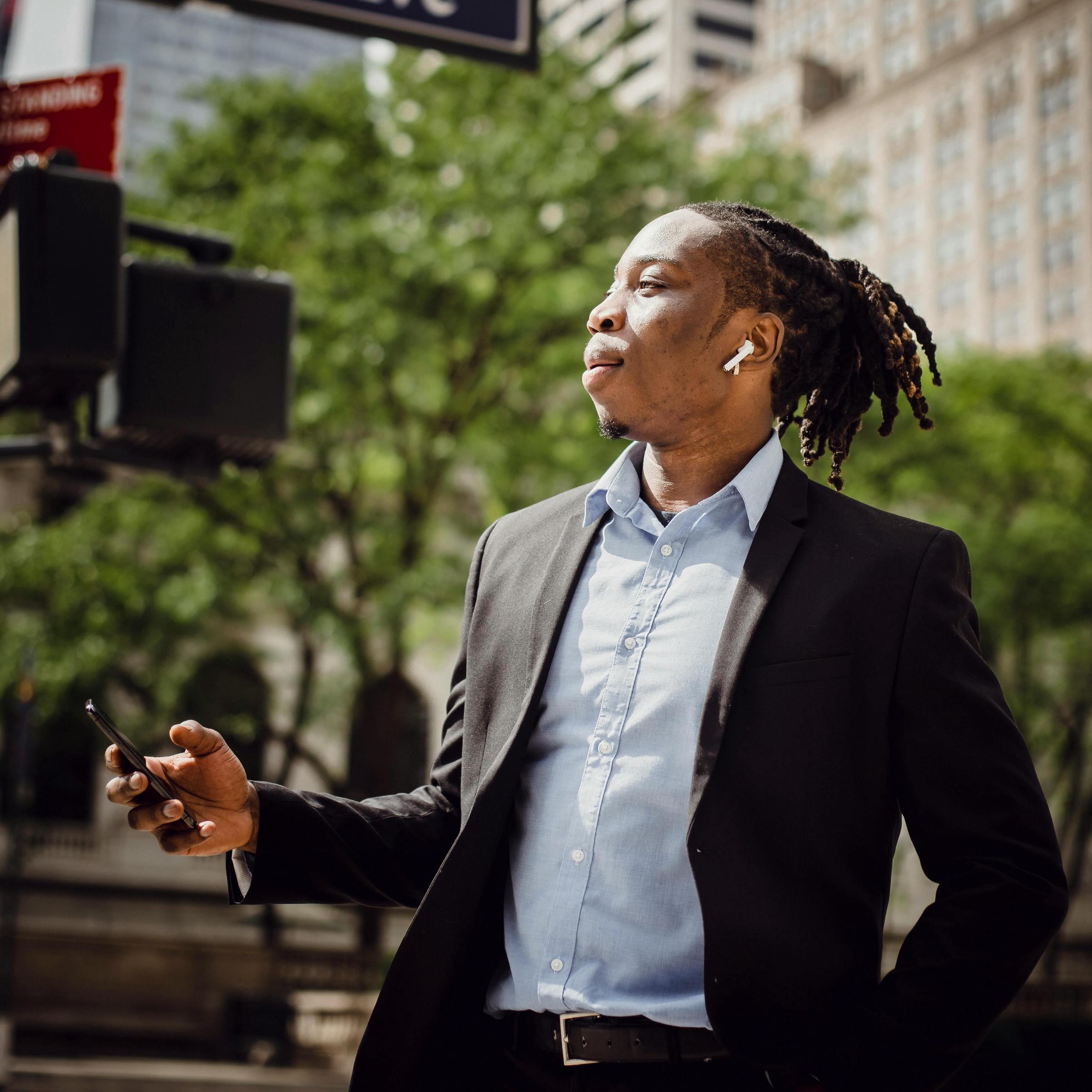 A smartly-dressed man operating a mobile phone | Source: Pexels