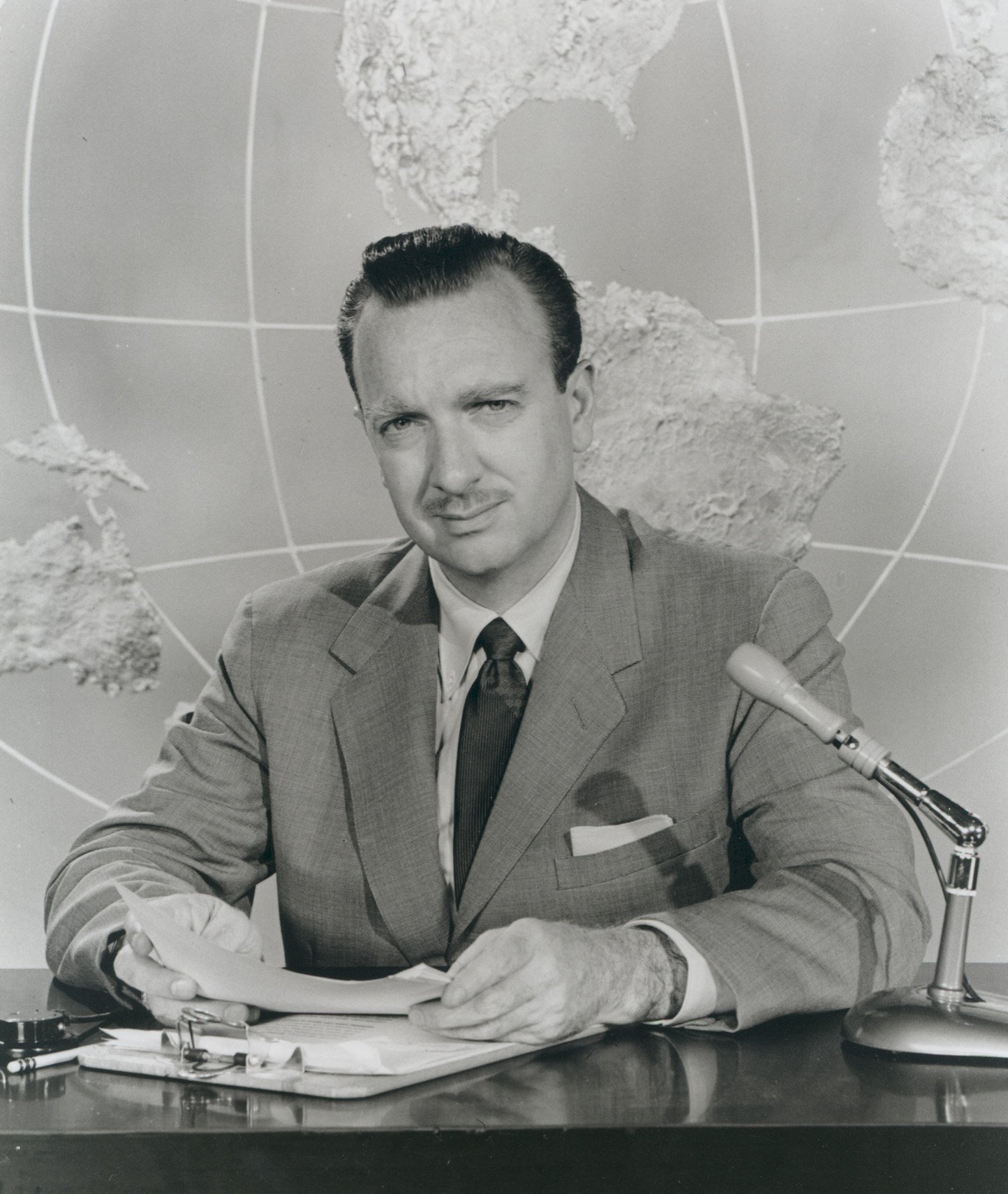 Promotional portrait of CBS "Evening News" anchorman, Walter Cronkite sitting behind a desk during mid the 1950s | Photo: Getty Images
