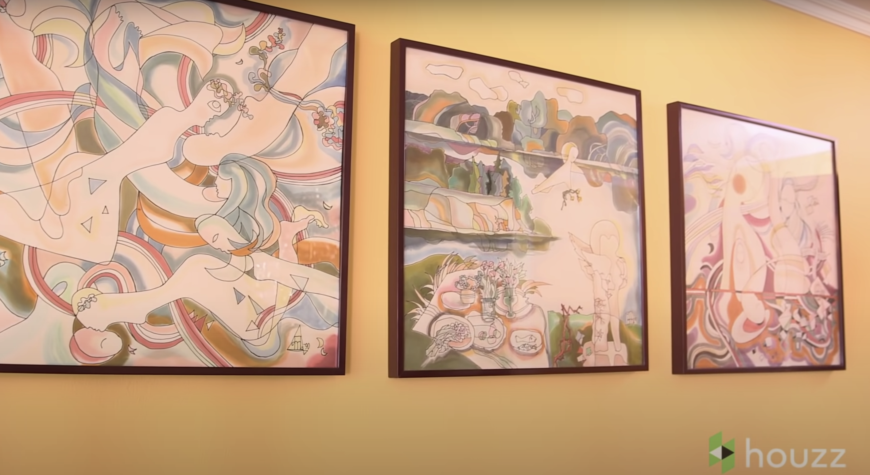 The three triptych paintings Mila Kunis' parents brought from Russia are displayed on the wall. | Source: Youtube.com/HouzzTV