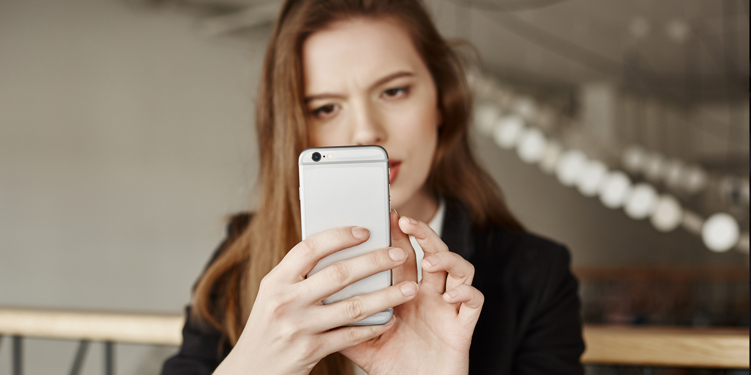 A woman frowning at her phone | Source: Freepik