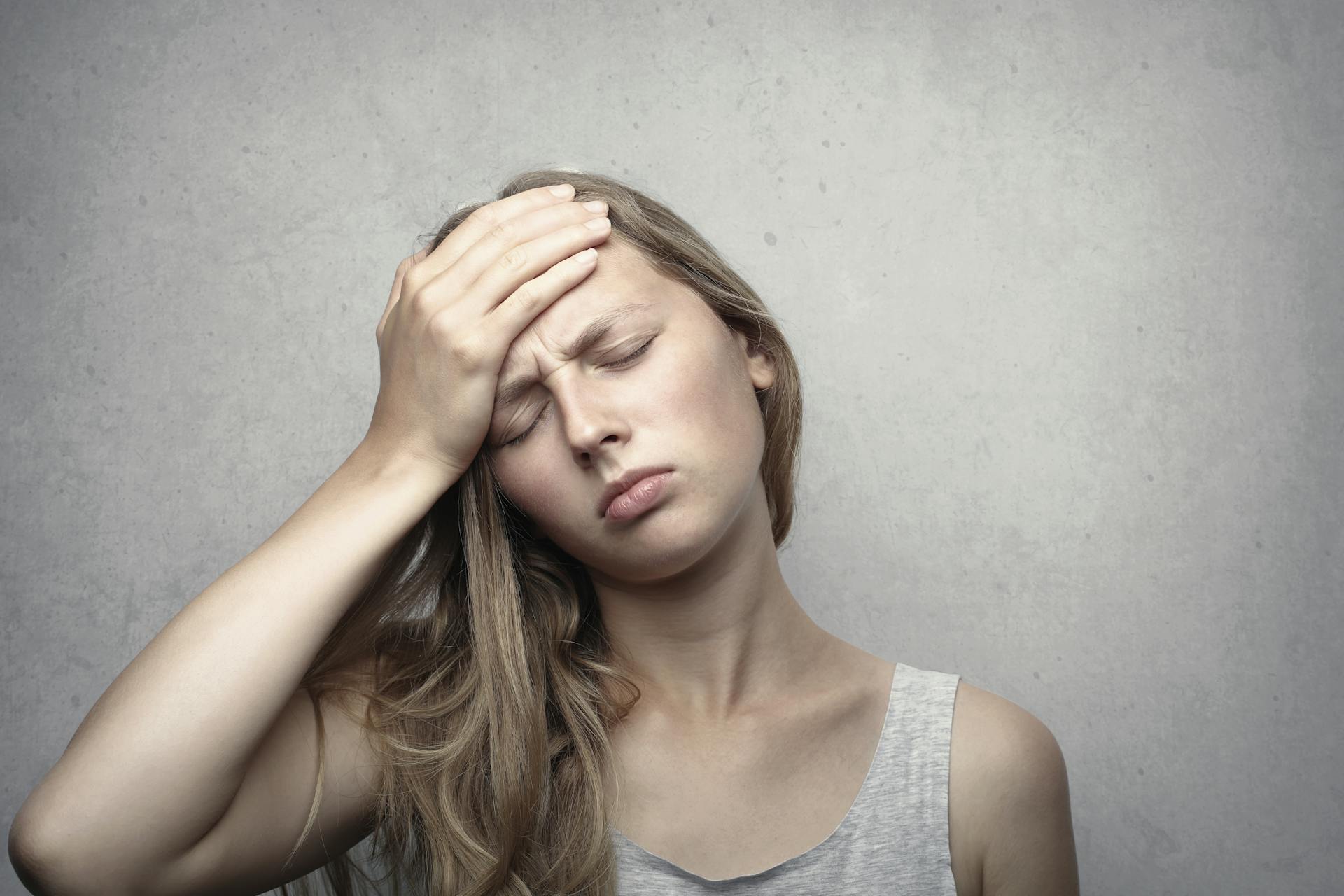 A frustrated young woman holding her head | Source: Pexels