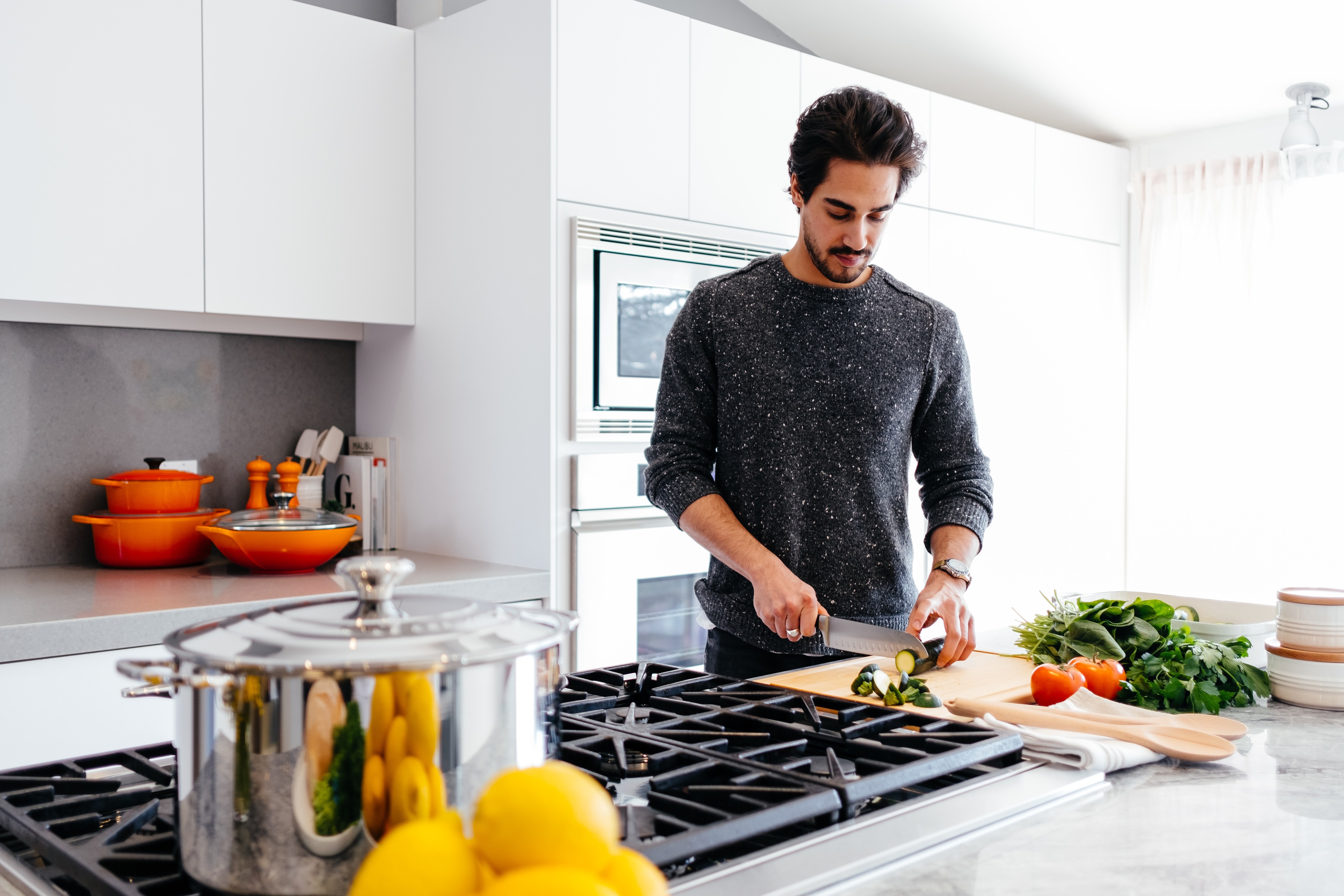 A man chopping vegetables on a kitchen counter. | Source: Unsplash