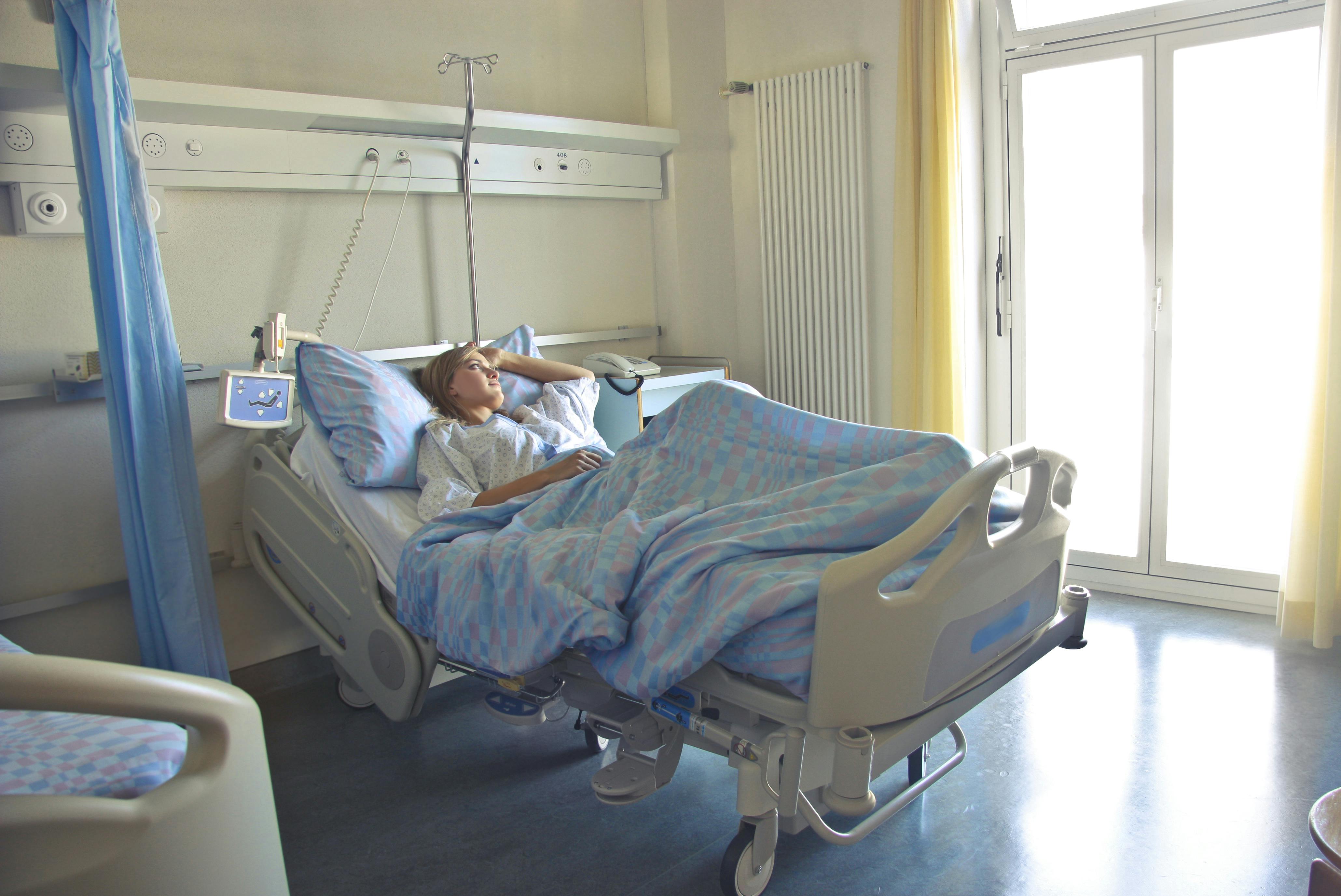 A woman looking outside while laying in a hospital bed | Source: Pexels